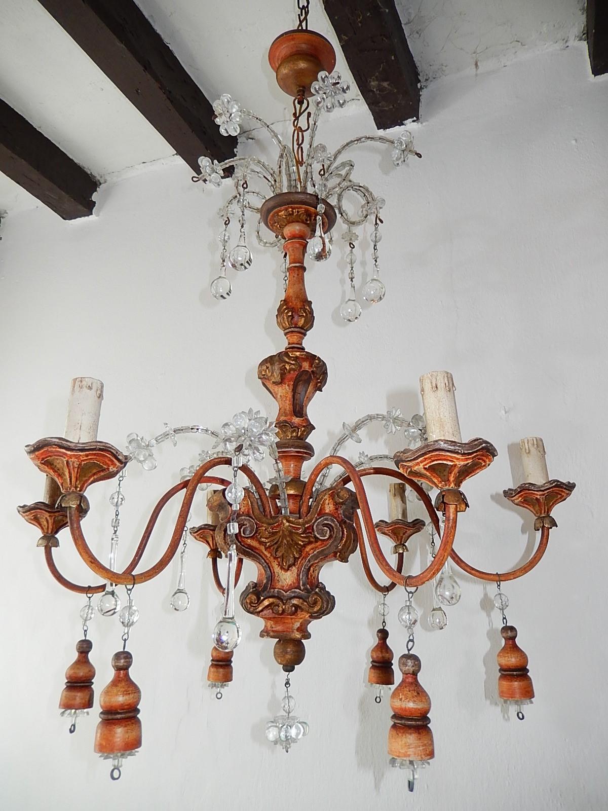 Housing 6 lights sitting in original painted wooden posts. Hand carved gold and rust color wood with metal arms. Beaded top with florets and clear Murano drops. Crystal macaroni with wooden tassels as well. Will be newly rewired with certified US UL