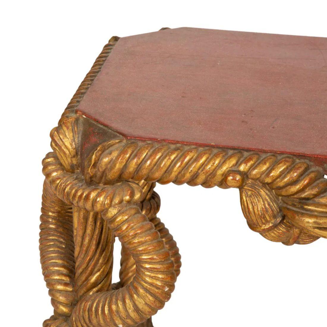 Dieser italienische Beistelltisch aus vergoldetem Kunstporphyr aus der Mitte des 20. Jahrhunderts zeichnet sich durch aufwändige Schnitzereien und eine luxuriöse Platte aus Kunstporphyr aus. Der Sockel aus vergoldetem Holz setzt einen eleganten
