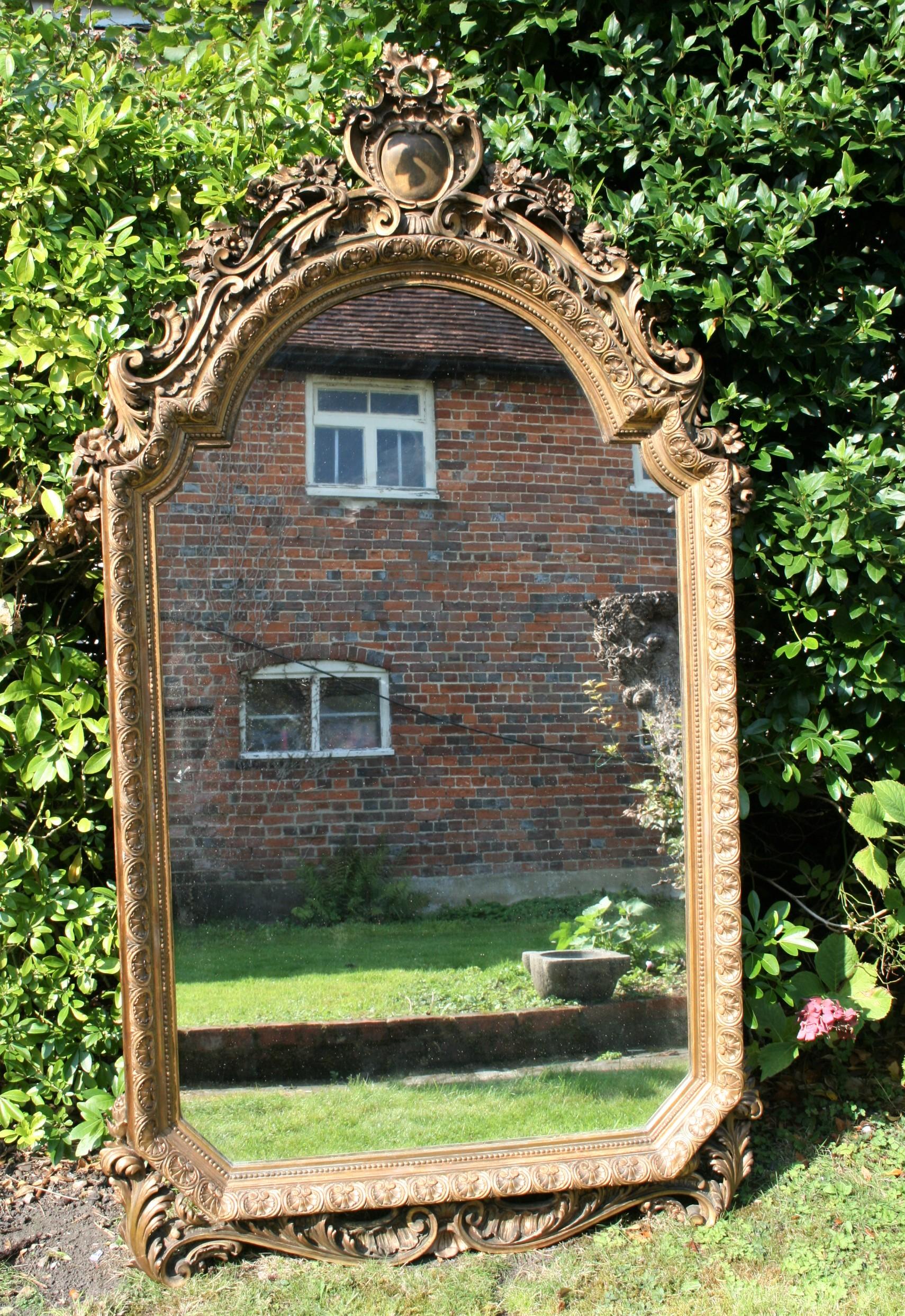 A good early 19th possibly 18th century mirror in crisply carved wood and a gilt finish. Some minor damage and rubbed gilt but overall a beautiful mirror with original plate.