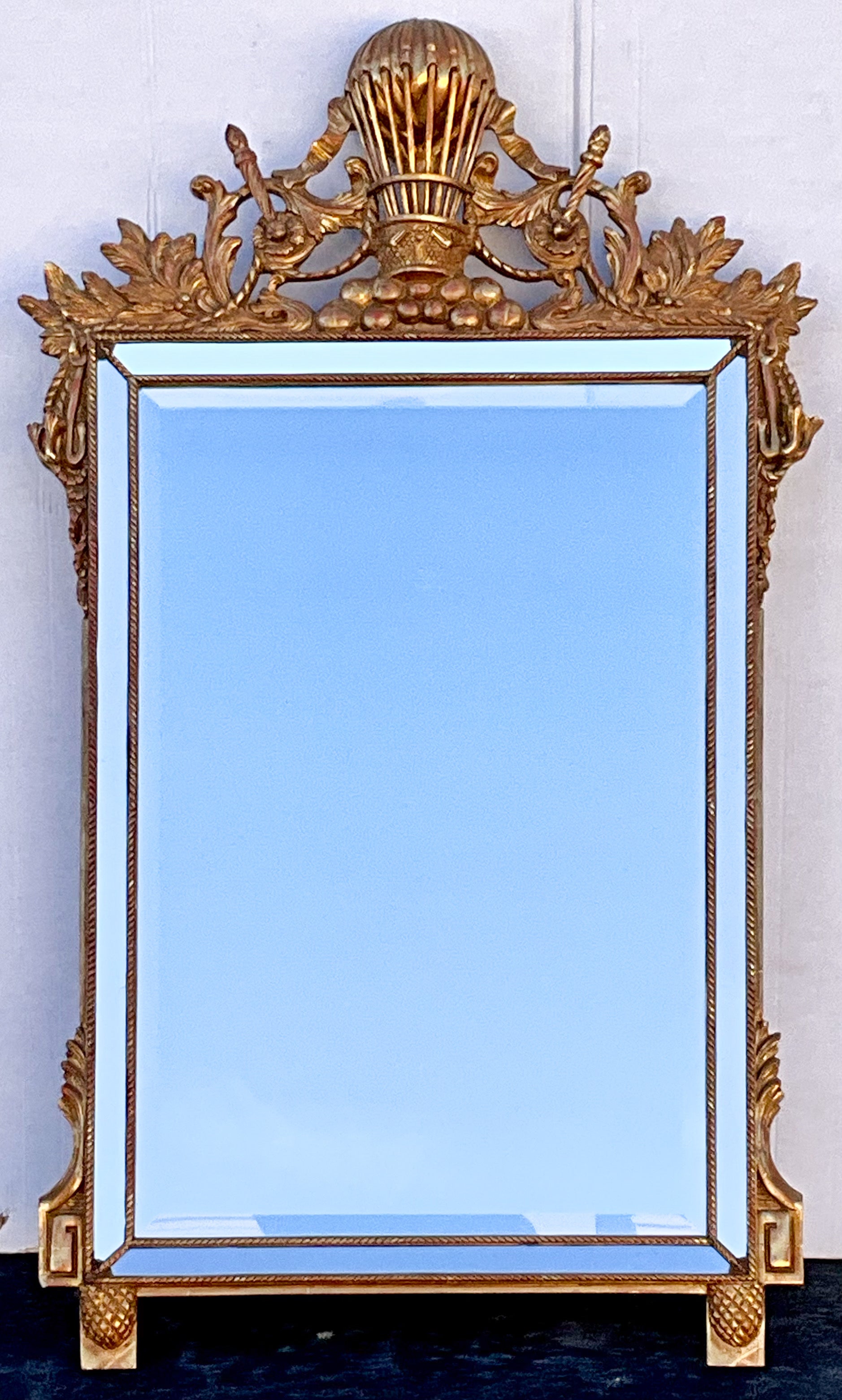 It is an Italian carved giltwood balloon form mirror with French Empire styling. It has mirrored frame and Greek key and tassel appointments. It is marked and in very good condition.








