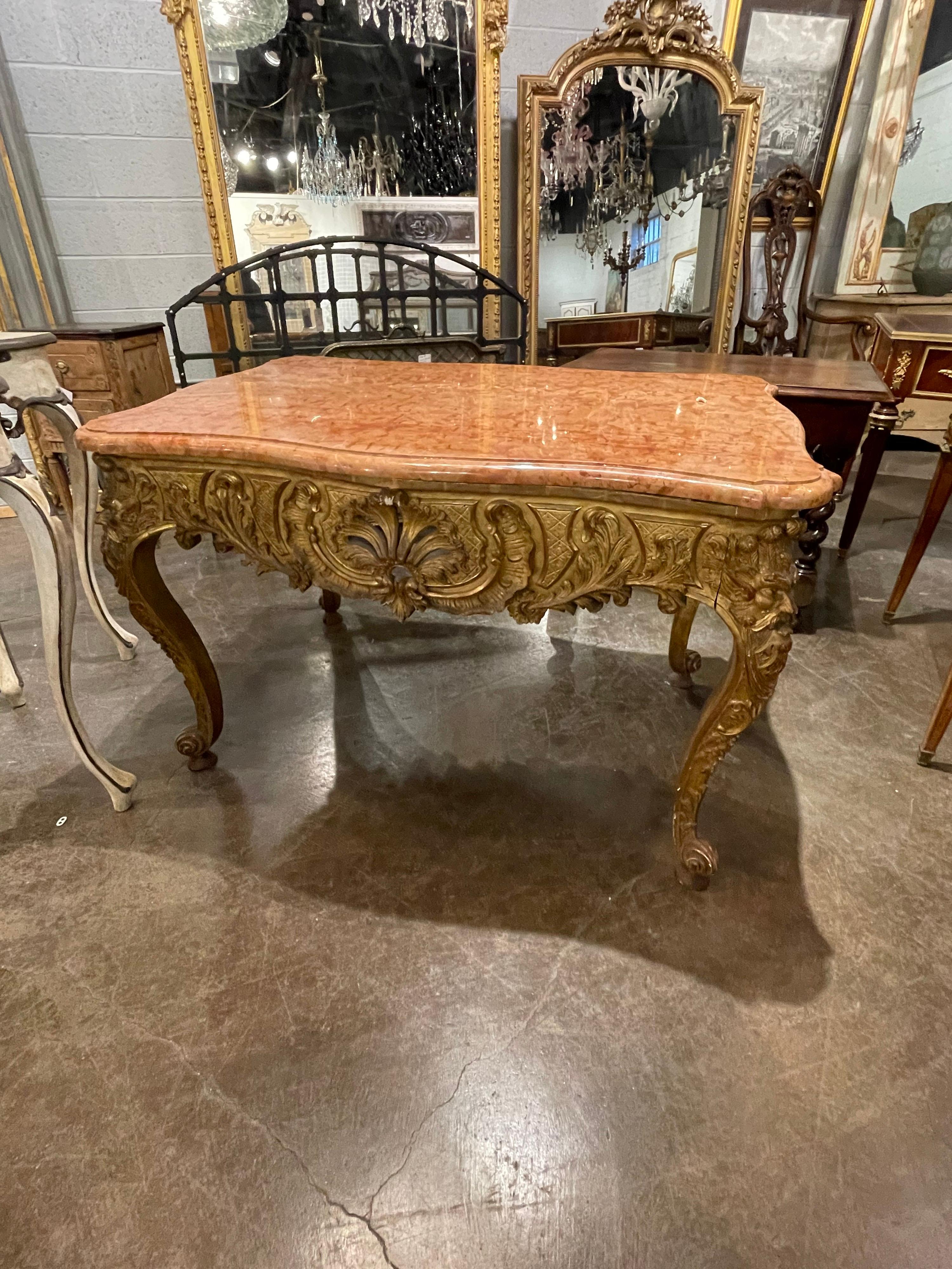 Superior quality 19th century Italian giltwood and marble top centre table. The apron ornately carved with scrolling leaves and shells. The corners with superbly detailed carvings of mythological masks.

The entire on elaborately carved cabriole