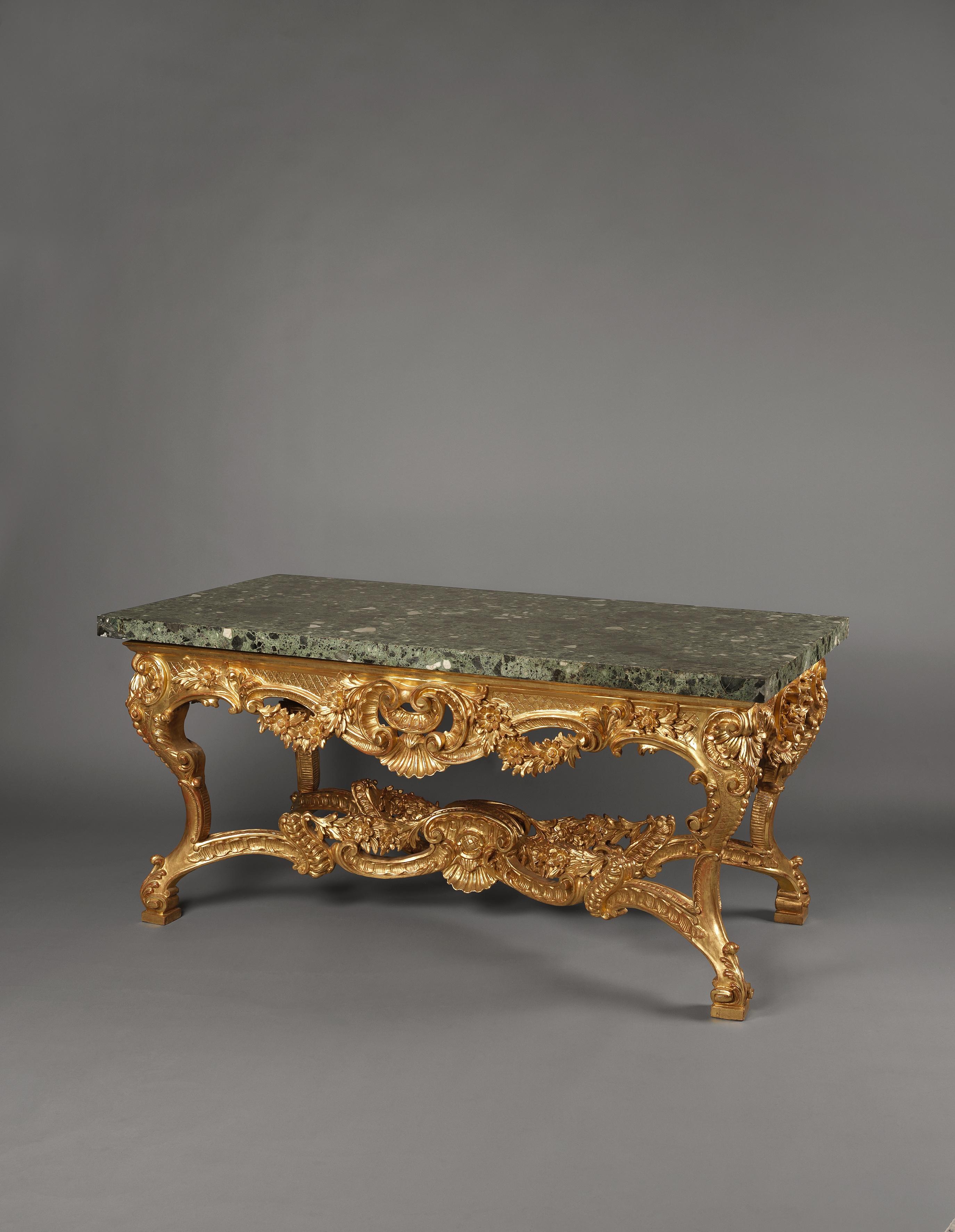 An impressive Italian carved giltwood centre table with a Verde Antico marble top.

Italian, circa 1860. 

The table has a shaped apron with diapered panels centred by an exuberent ‘C’-scroll and scallop shell cartouche with foliate garlands. It