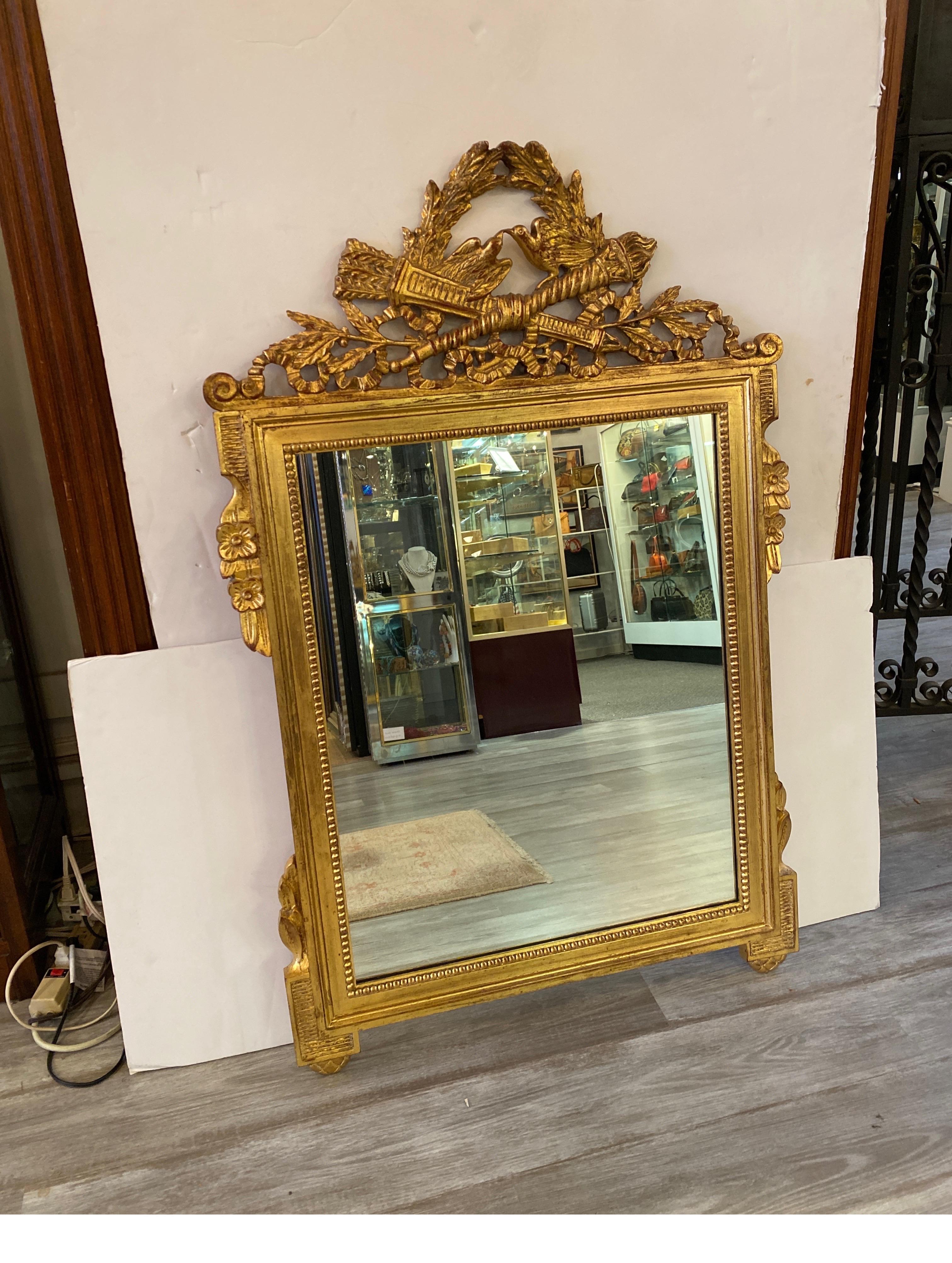 Stunning real gilt wood mirror made in Italy by Padillo for Kindel Furniture.
Beautiful mirror!  This well designed piece by Palladio is made of hand carved wood with a gold gilt finish. It depicts laurel leaf designs with eagles, ribbons and