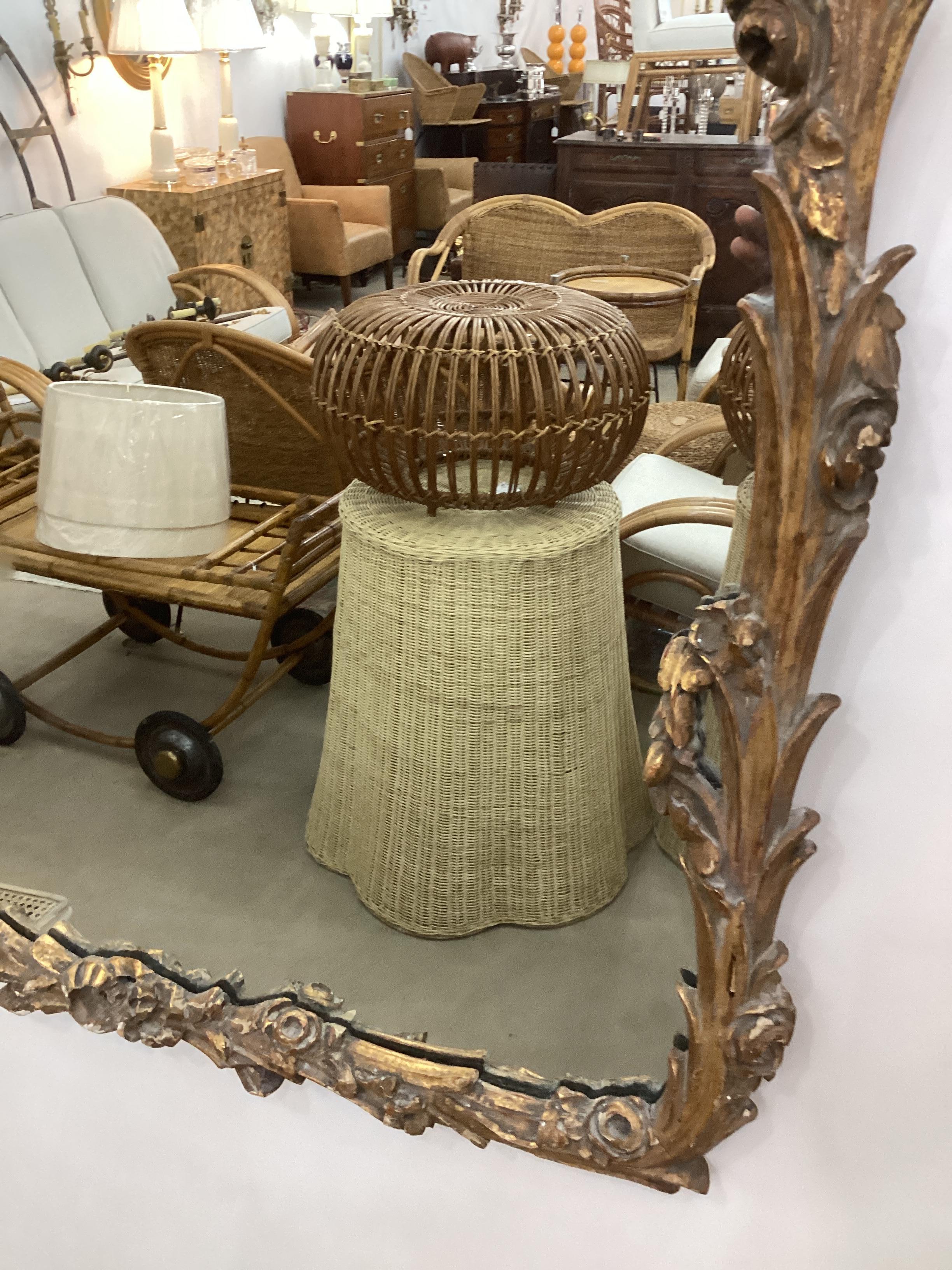 Italian Carved Giltwood Mirror. Intricately carved with floral accents. In good vintage condition with minimal losses and old repairs.