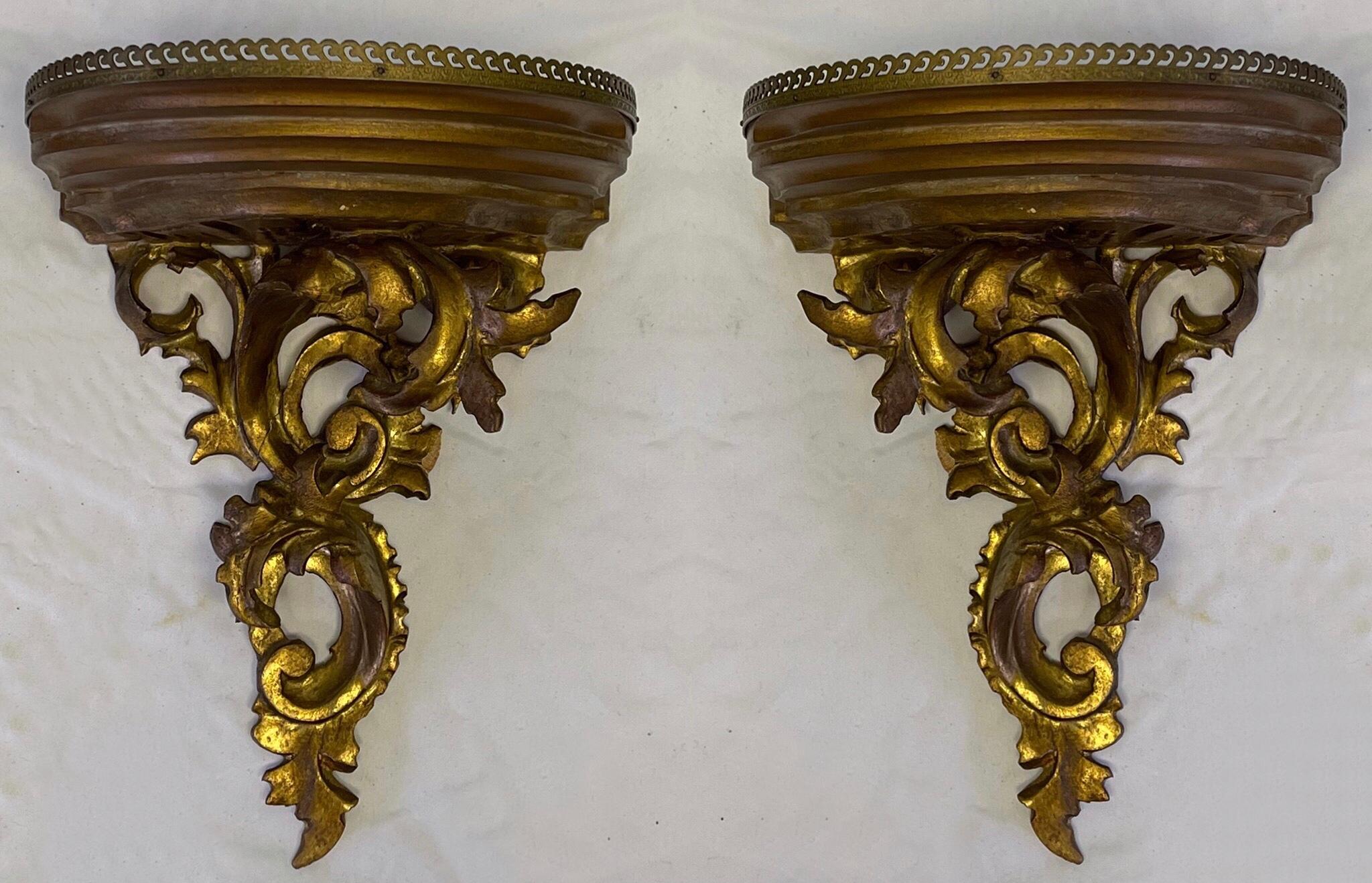 This is a pair of carved giltwood Rococo style wall brackets with walnut platform and brass gallery. They date to the 50s/60s and are in very good condition.