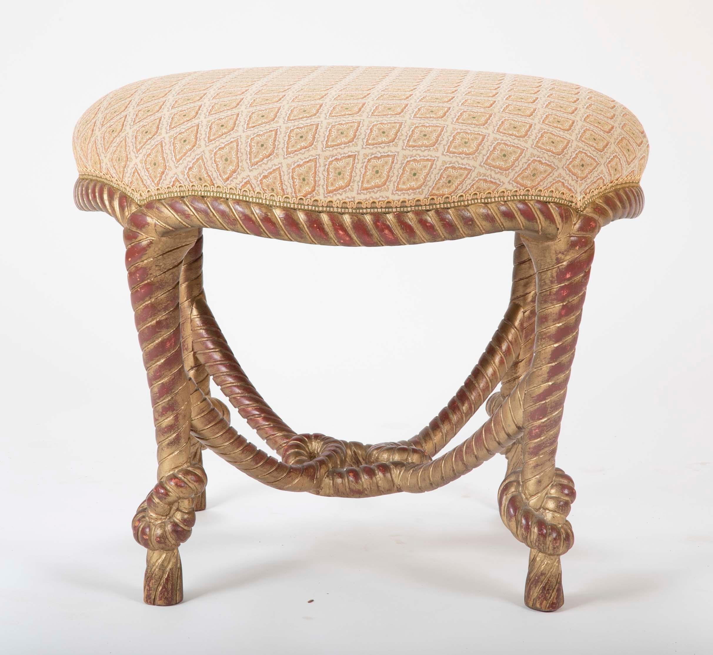 An elegant midcentury Italian hand carved and giltwood twisted rope stool with tassel feet. What is particularly appealing is the red bol showing through the gilding giving the surface a warm patina. A good size at 24 inches diameter.