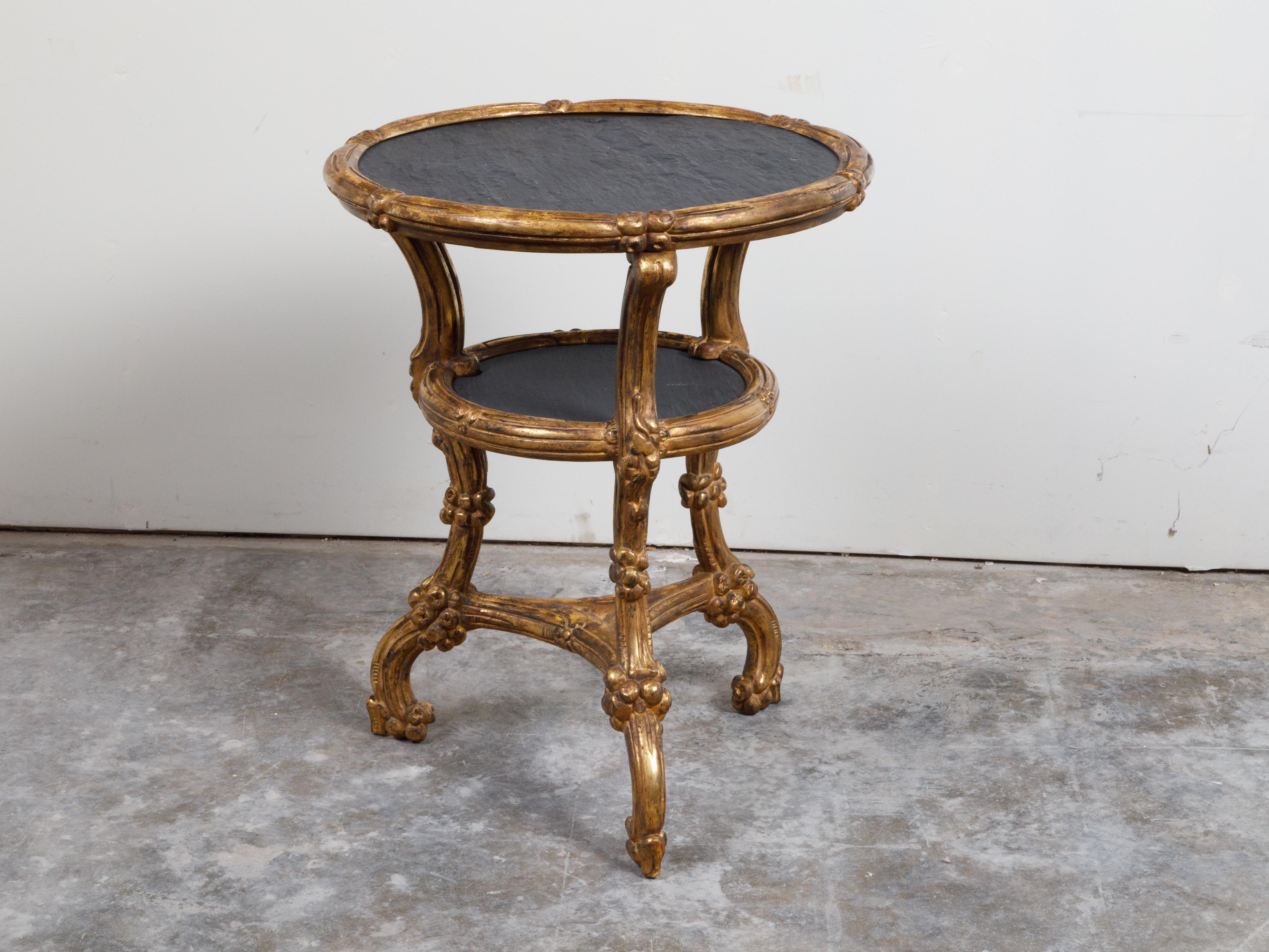 An Italian giltwood side table from the early 20th century, with slate top, shelf and cabriole legs. Created in Italy during the early years of the 20th century, this giltwood side table features a circular slate top resting on three curving