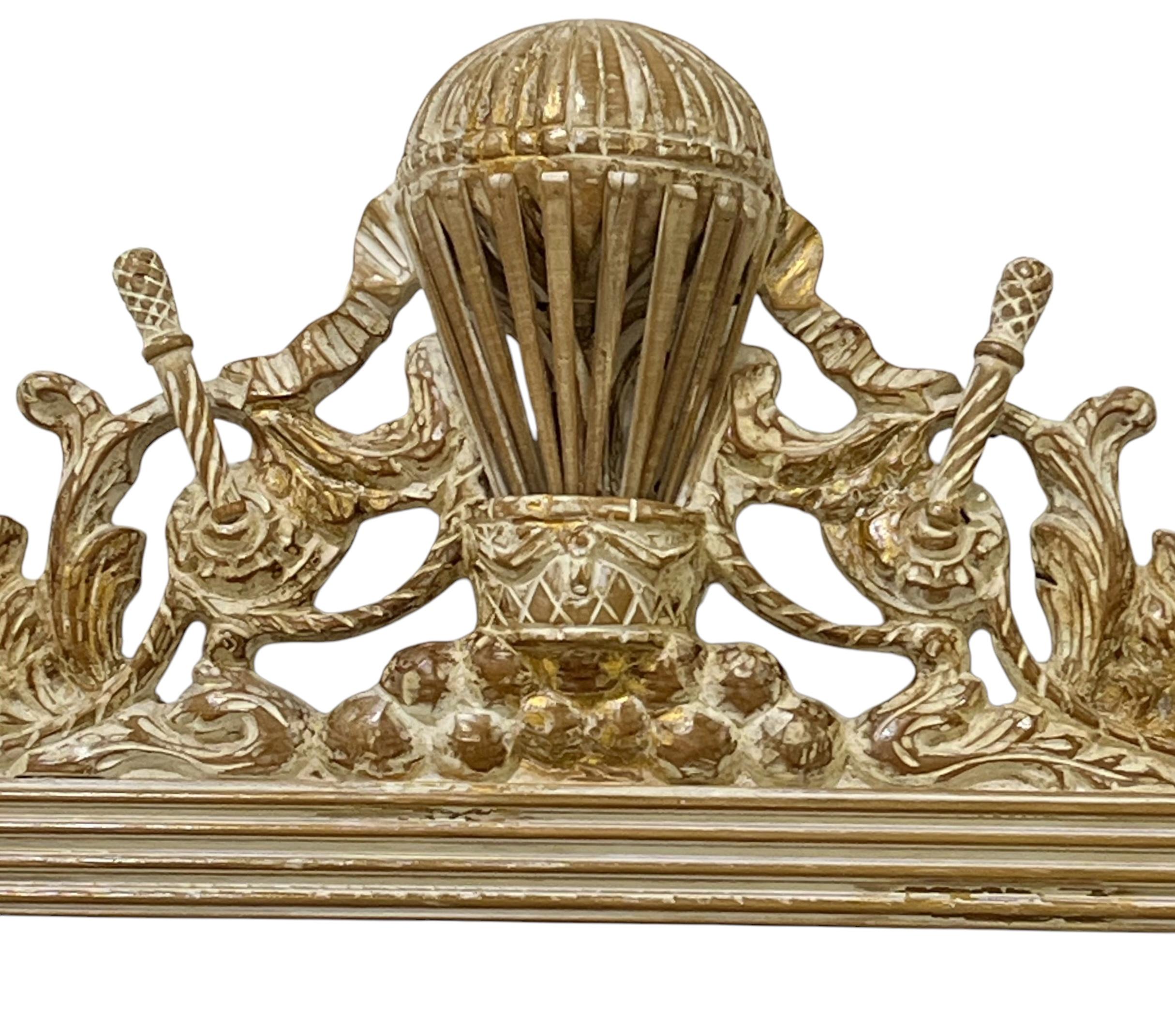 It is an Italian carved giltwood and whitewashed balloon form mirror with French Empire styling. It has tassel appointments. It is in very good condition.







