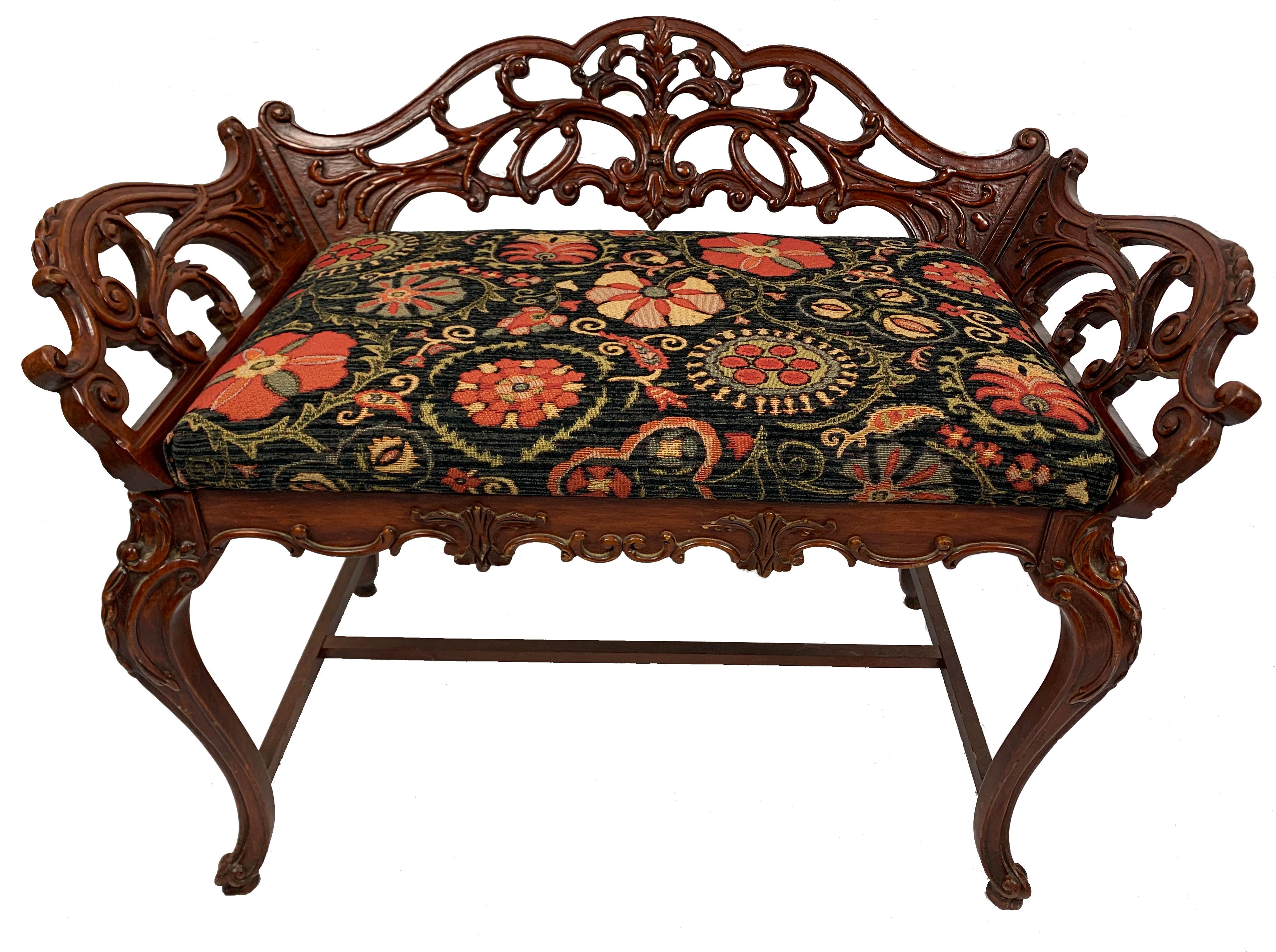 An exquisite, highly carved Italian wooden bench or vanity seat from the 19th century with upholstered seat.