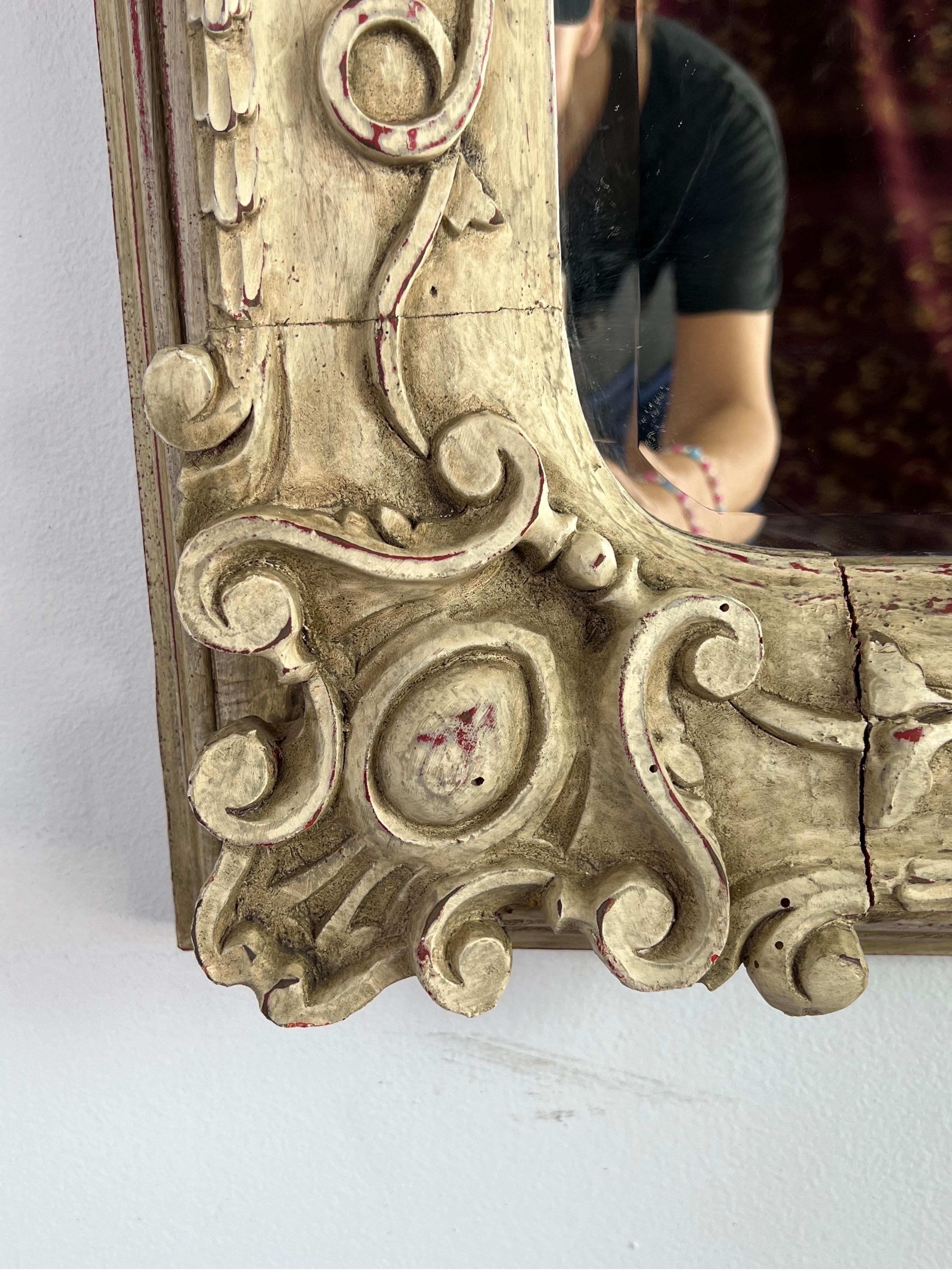 1940's Italian carved painted mirror with beautiful carved details throughout. There are shells, cartouches in corners, flowers, leave and more. Some wear to paint and cracks expected with the age of the mirror.