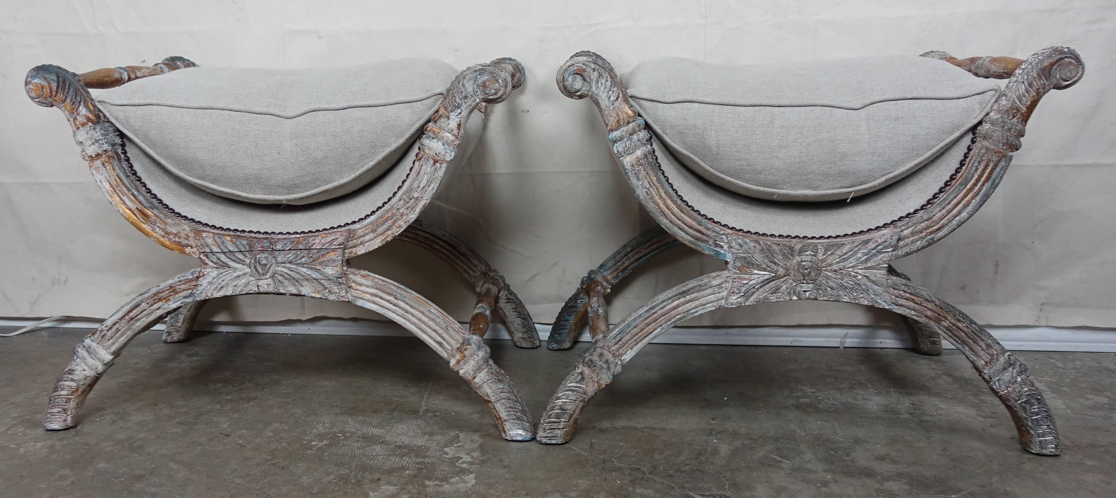 Italian carved wood painted and parcel-gilt benches that have been newly upholstered in Belgium linen with nailhead trim detail. Loose down filled cushions.