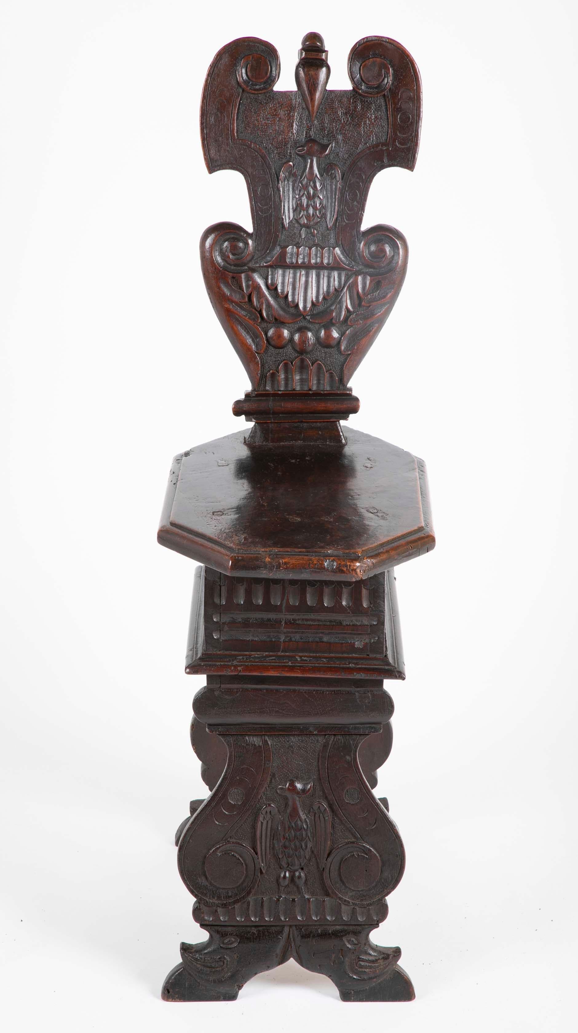A late 16th, early 17th century walnut sgabello, or hall chair with a cartouche shaped back carved with an eagle in relief. The octagonal seat above scrolled supports, also carved with the image of an eagle. This is the classic late Renaissance,