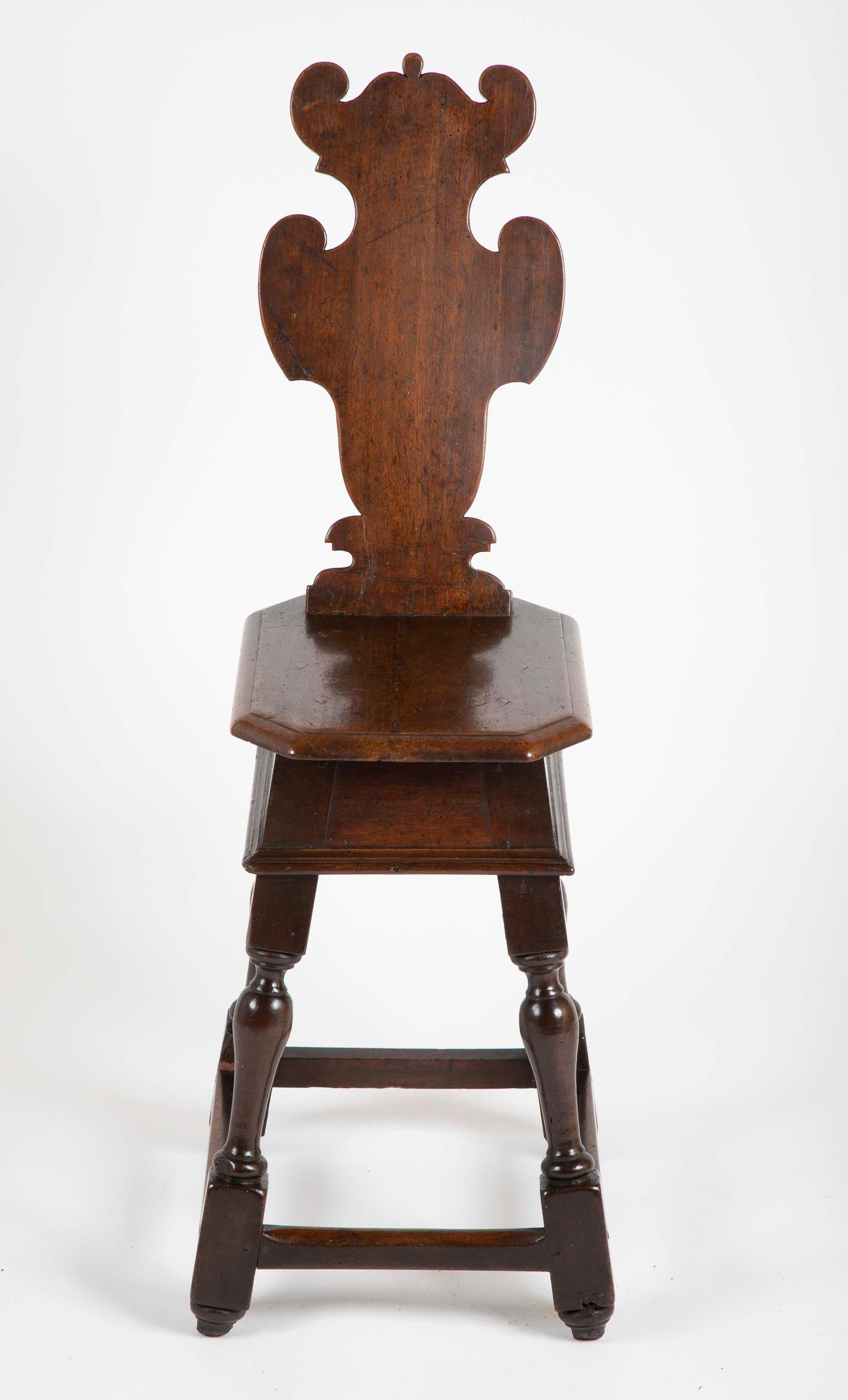 A late 16th-early 17th century walnut sgabello, or hall chair with a cartouche shaped back over an octagonal seat above scrolled supports. This is the Classic late Renaissance, early Baroque form of a hall or occasional chair, really a stool with a