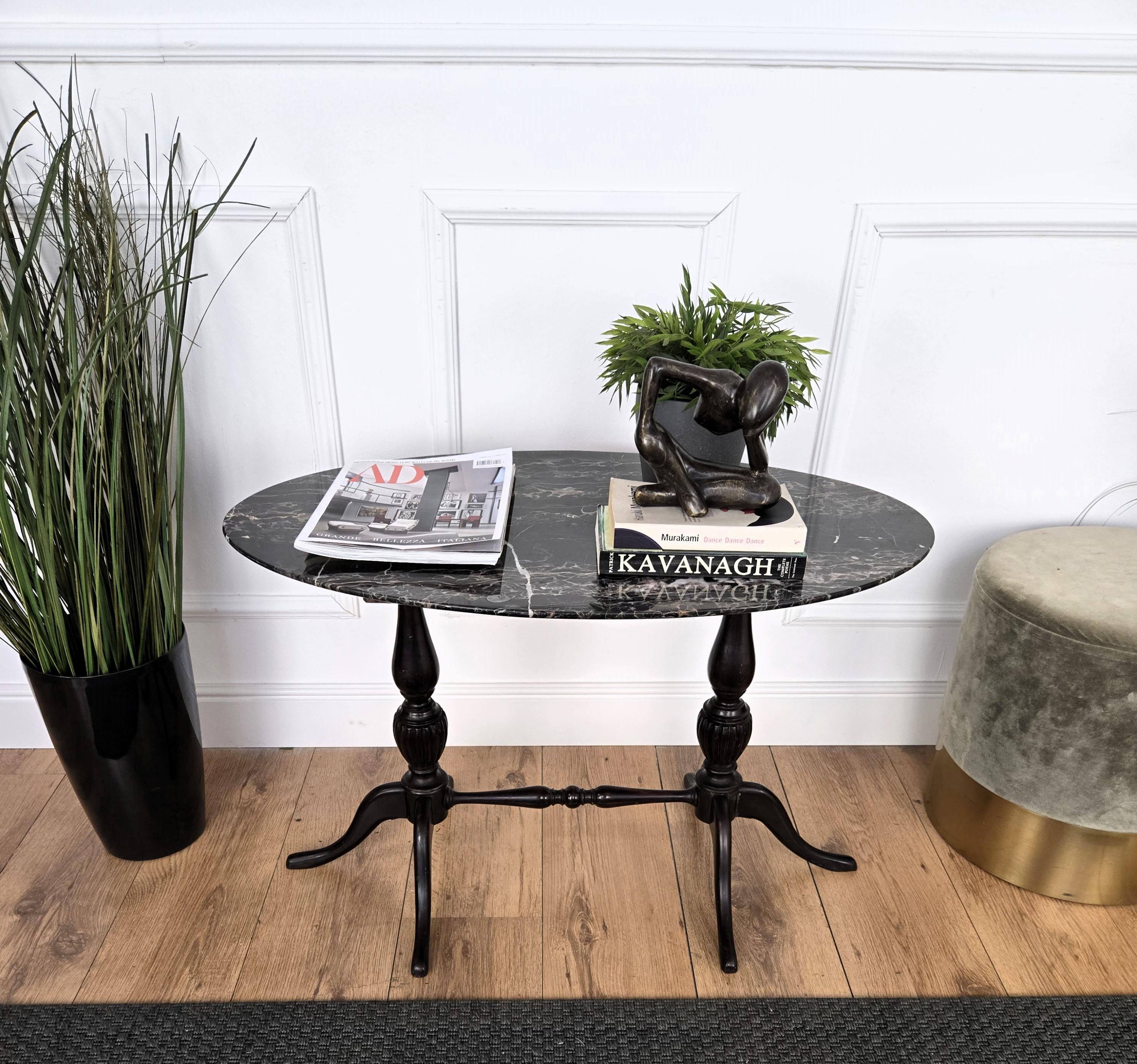 Très charmante et élégante petite table basse d'appoint italienne avec d'élégants pieds en forme sculptés en bois massif et complétés par le magnifique plateau en marbre Portoro. Le Portoro est un marbre noir de haute qualité, dont le vaste noir