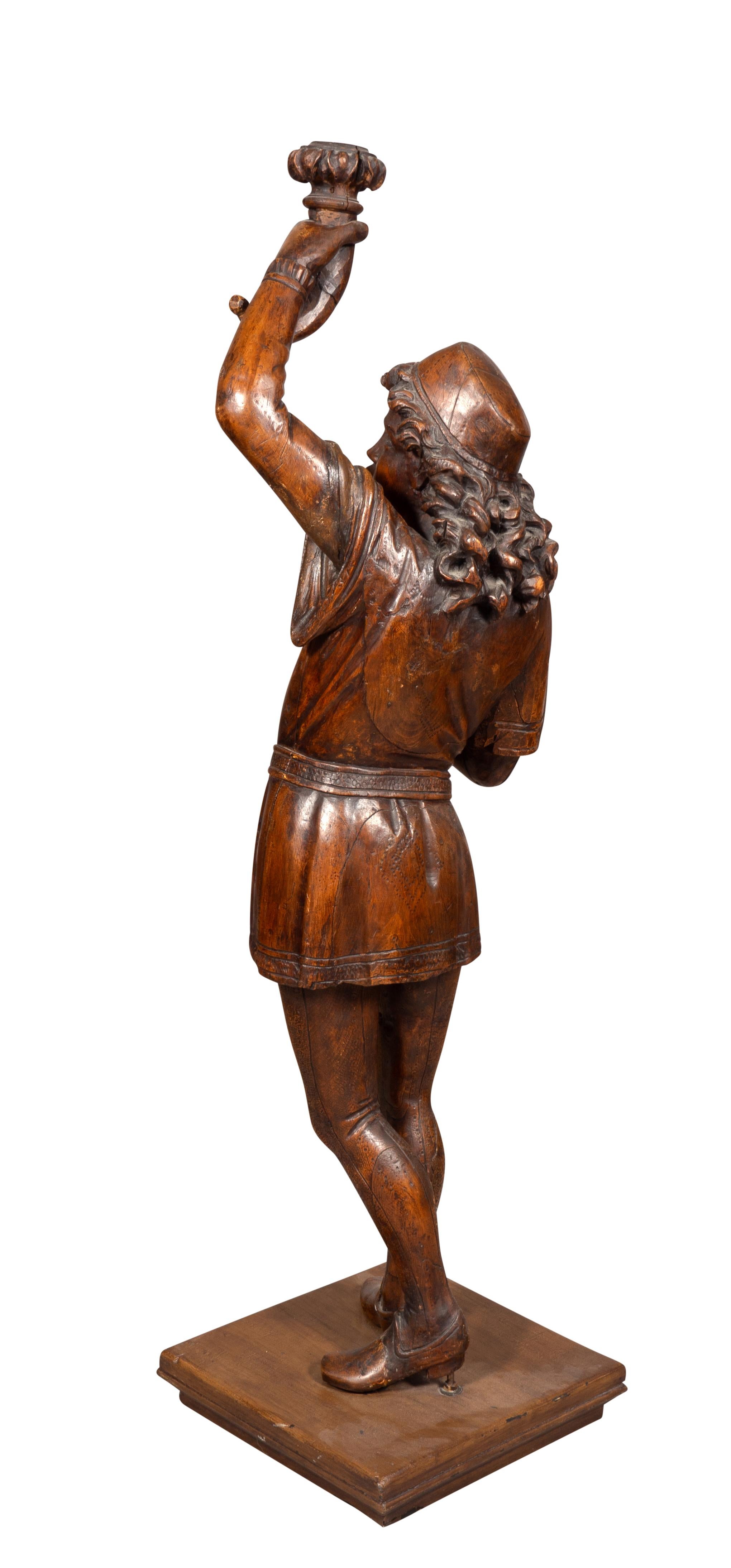 19th Century Italian Carved Walnut Torchere Of A Standing Boy Holding A Torch For Sale