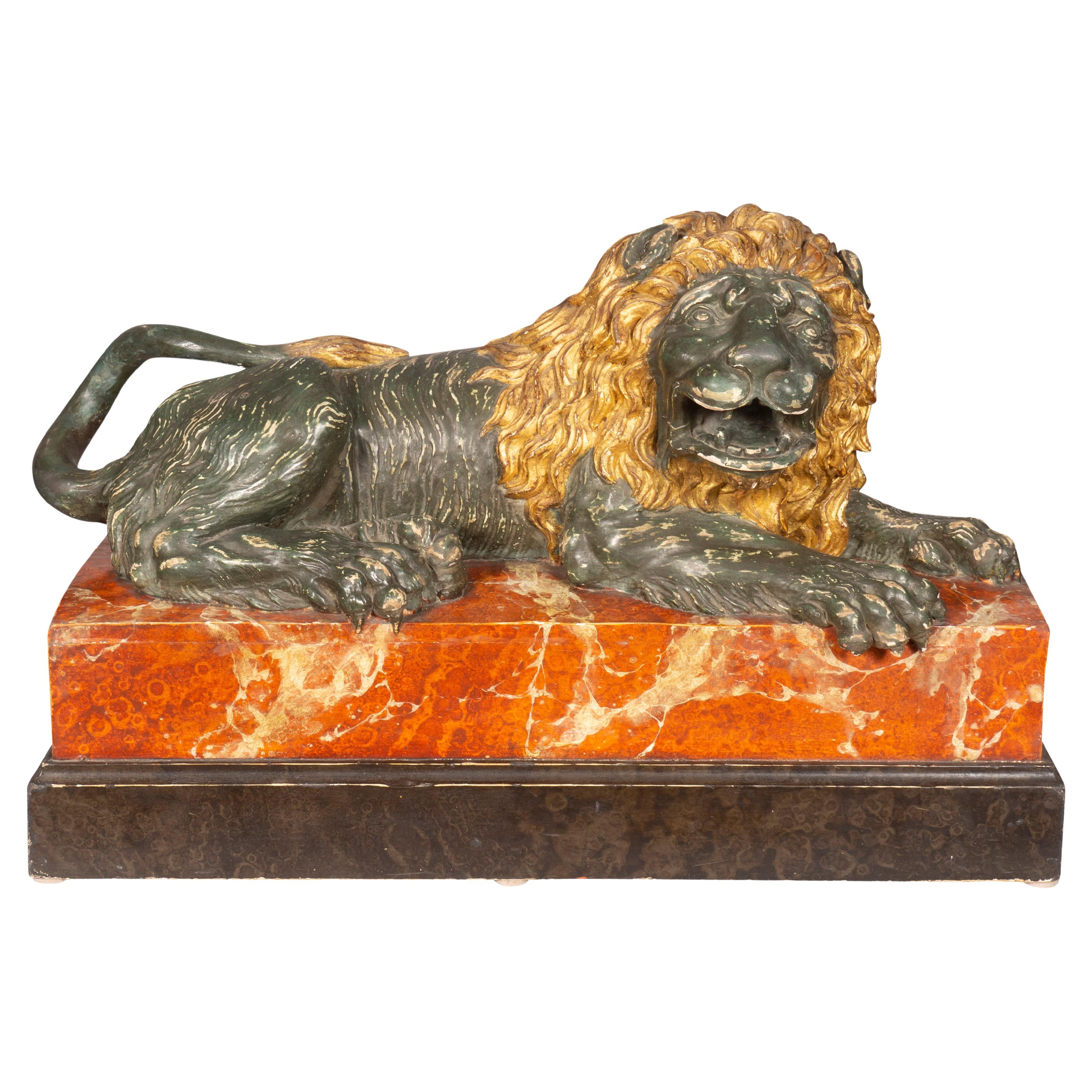 Le lion couché italien en bois sculpté et peint en vente