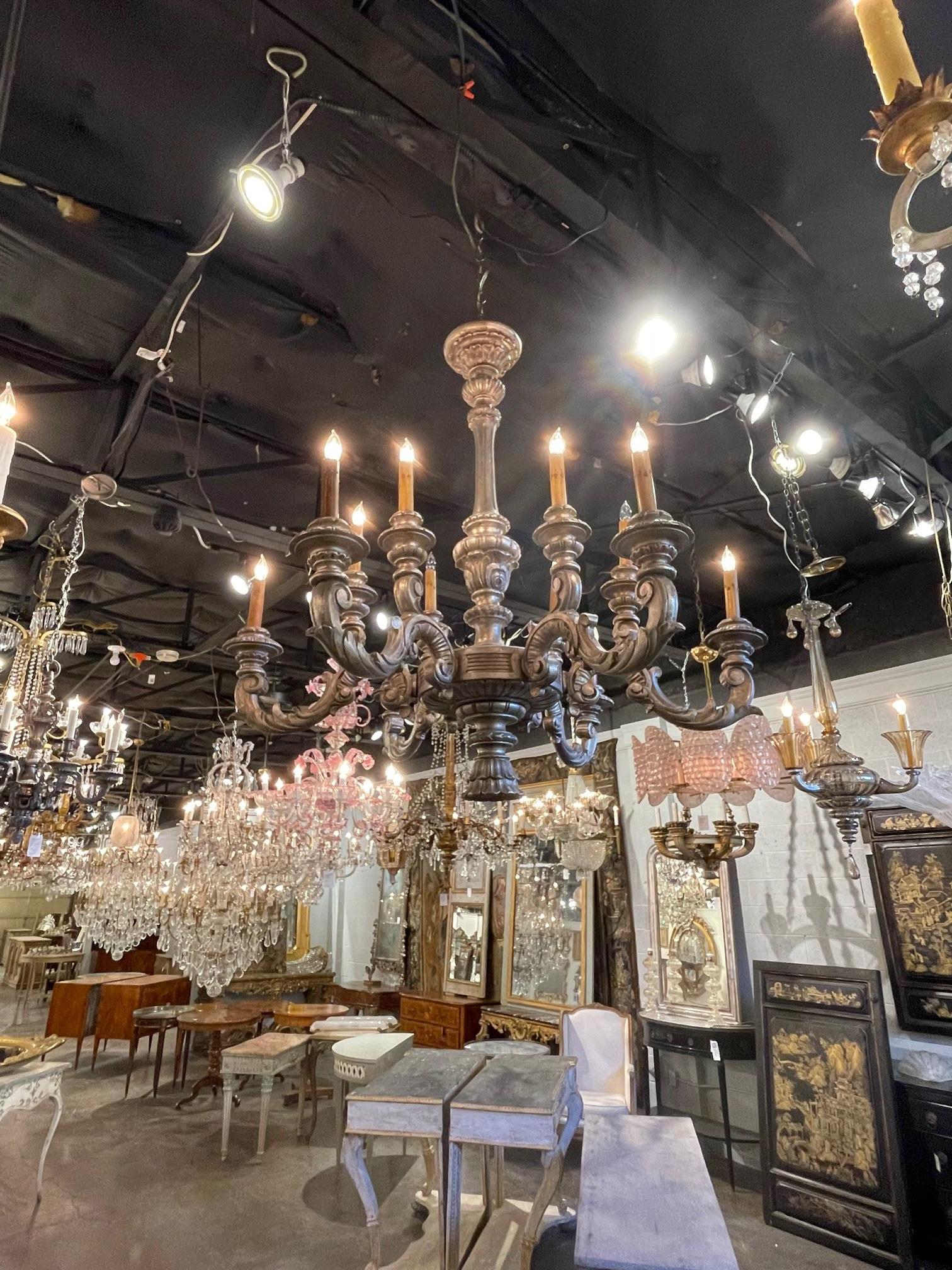 Italian carved and silver gilt wood 12-light chandelier, Circa 1920. The chandelier has been professionally re-wired, cleaned and is ready to hang. Includes matching chain and canopy. Sure to make a statement.