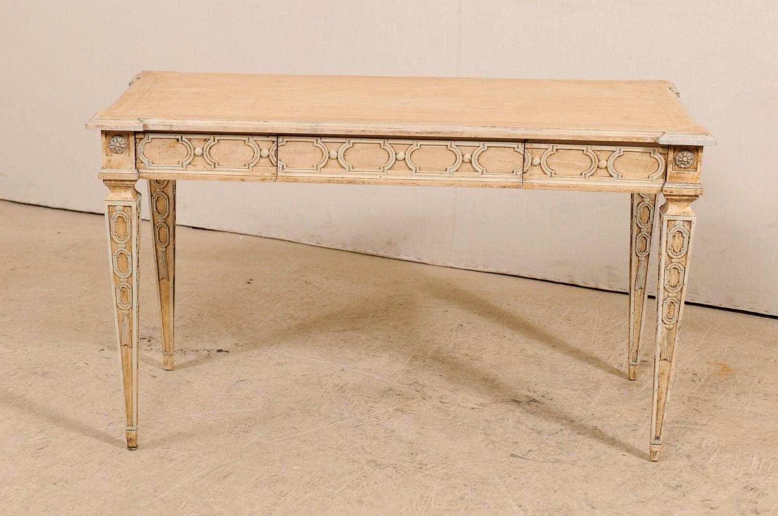 A nicely carved Italian table with hidden drawers. This lovely table from Italy features a rectangular shaped top with extended corners, above a skirt carved with petite flowers at each corner, and arch sided rectangular trim within a molded frame,