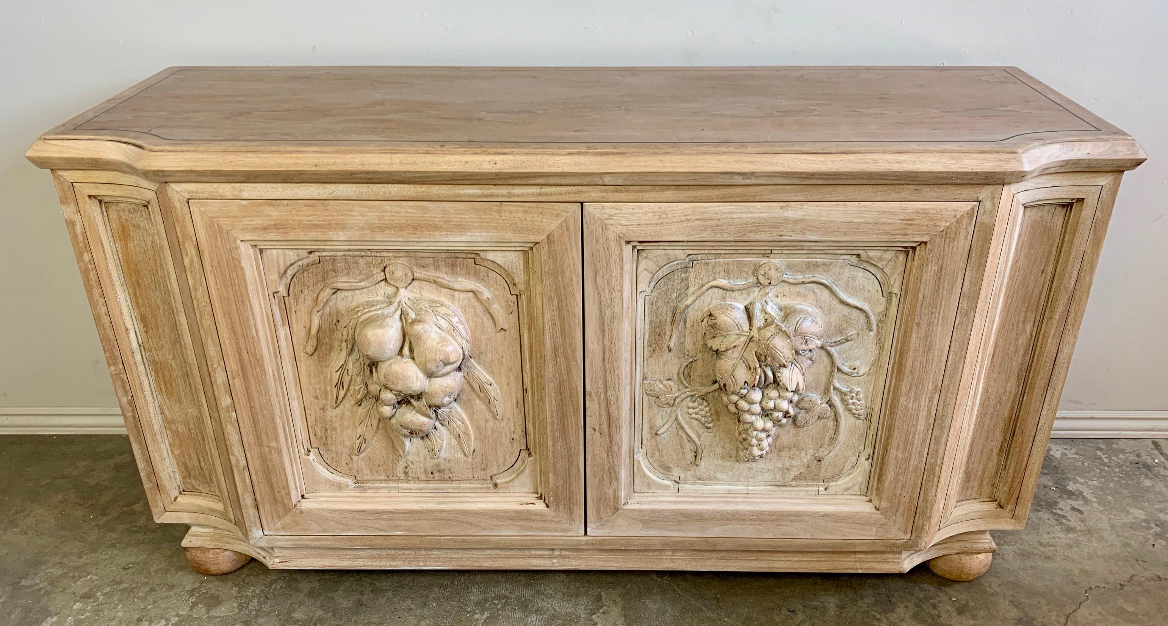 Beautiful Italian credenza in natural bleached walnut with detailed hand carved fruit panels on both doors.
