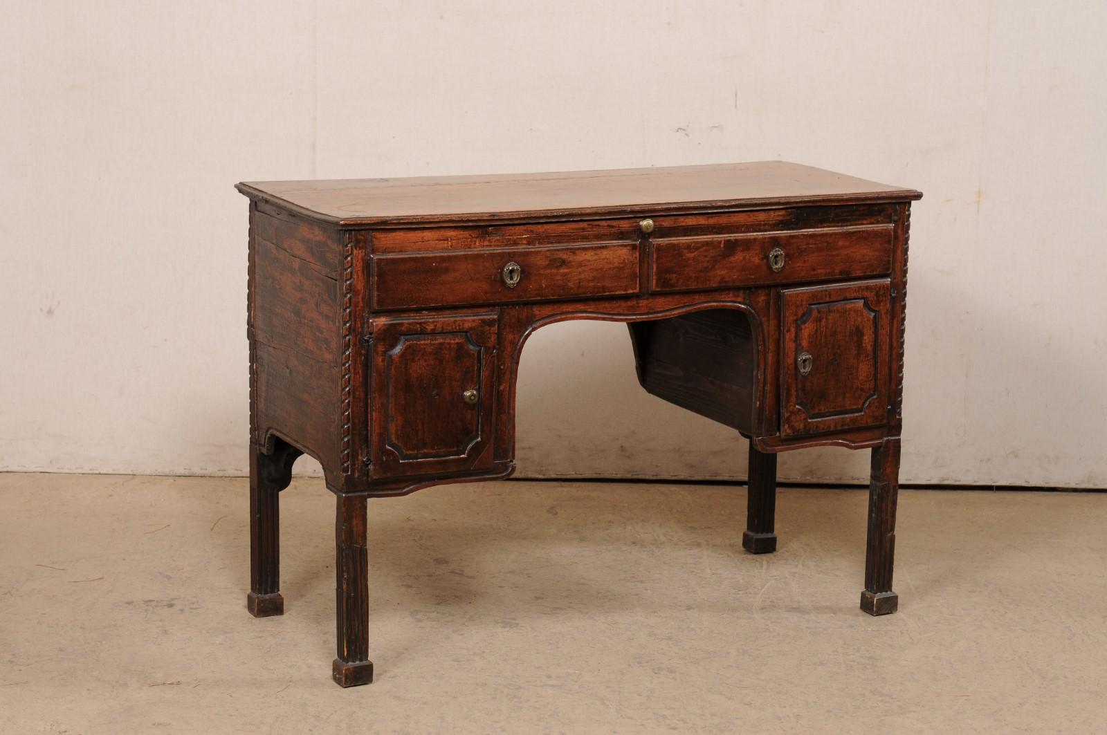 An Italian smaller-sized carved-wood desk, with pull-out writing shelf and storage, from the 19th century. This antique table from France features a rectangular top, approximately 3.75 feet in width, atop an apron which houses a slender pull-out