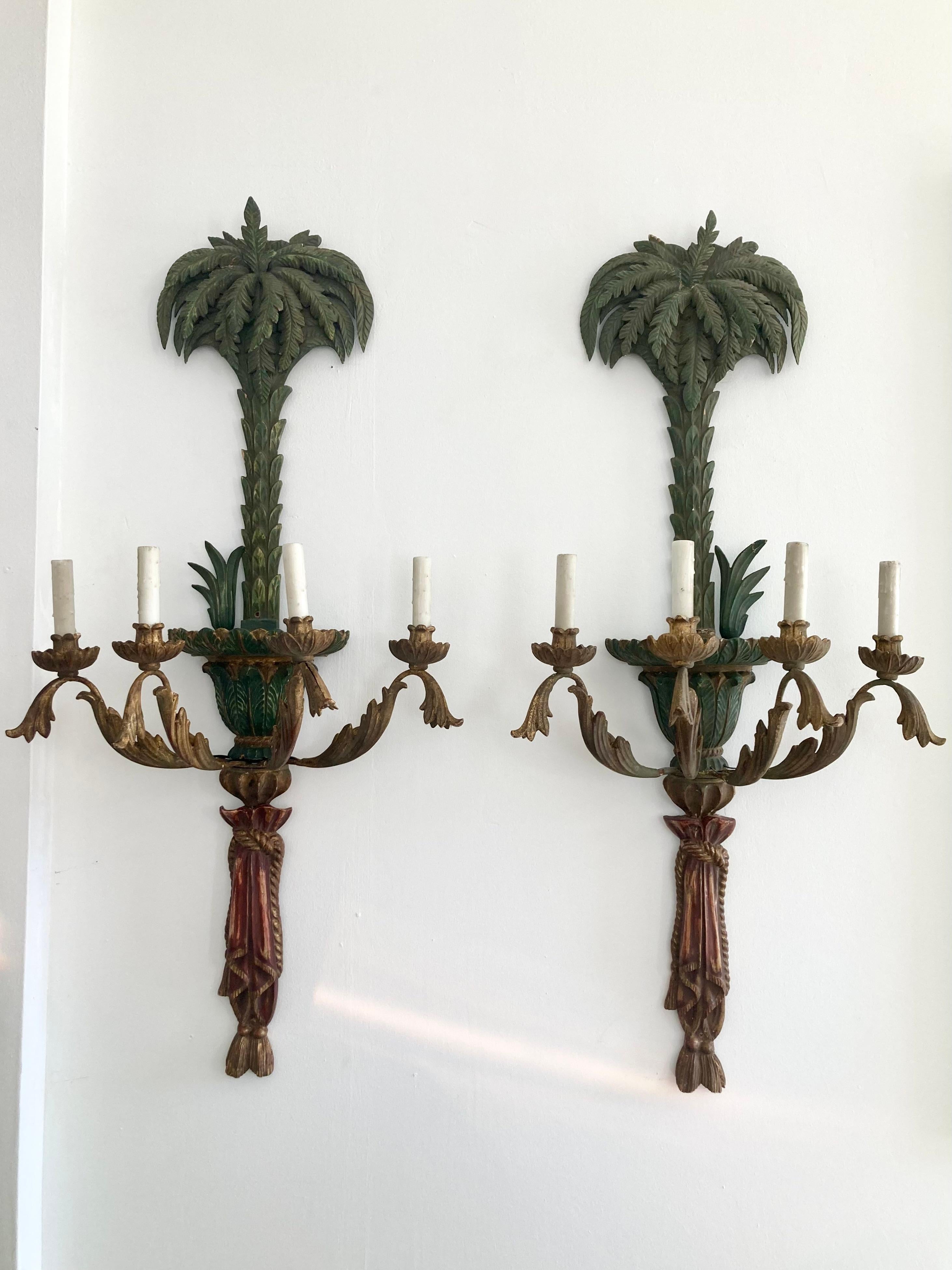 Beautiful pair of Italian carved wood palm tree wall sconces. Incredible details. The wiring goes out the back in the center so you will need an electrician to install. Add some real Hollywood Glamour to your home. We have a second pair available so