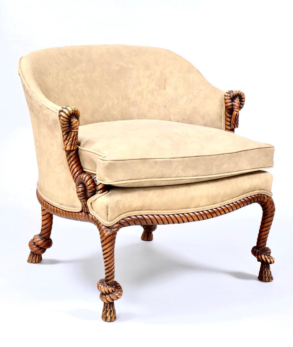 Chic and stylish pair of tub chairs having faux leather upholstered seats and backs with extraordinary carved wood rope and tassel decorated legs and arms. carved decorative. Chairs have the illusion of twisted and knotted rope along front arms,