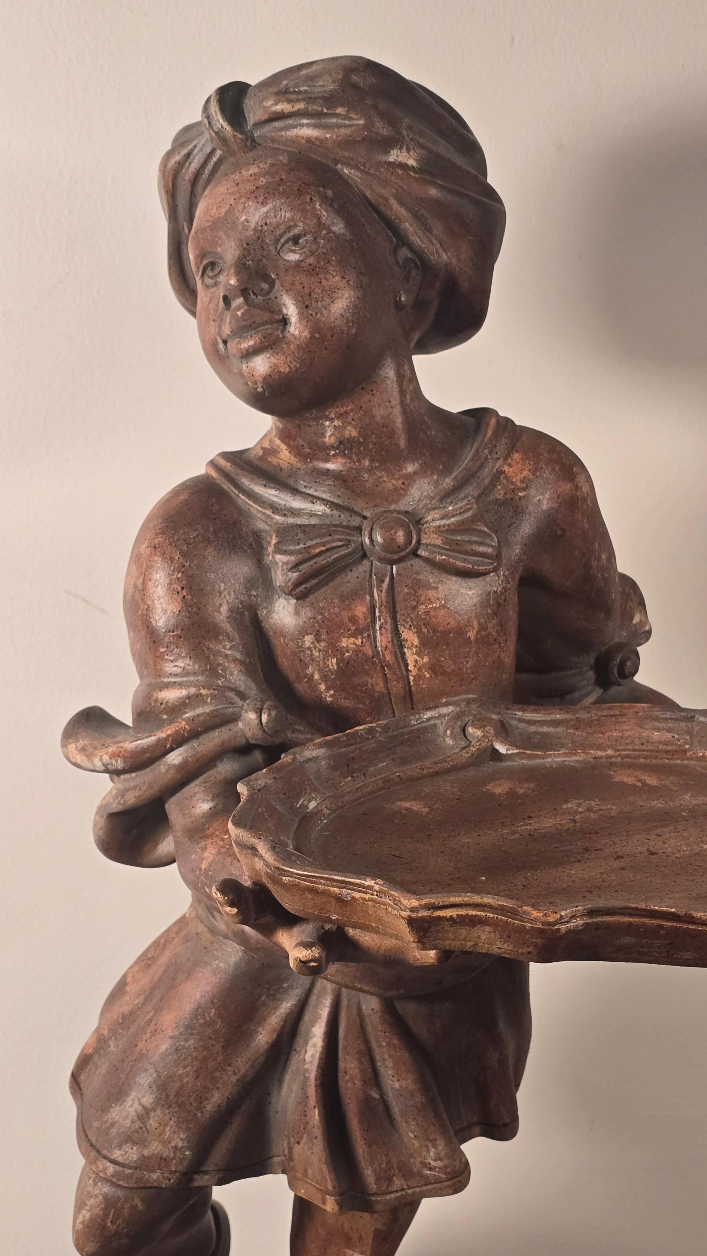 Una figura in legno finemente intagliata e dipinta a mano di una giovane ragazza che tiene in mano un vassoio sagomato, probabilmente prodotta a Venezia, in Italia, negli anni '60. In piedi con leggiadro portamento in cima a un basamento stilizzato,