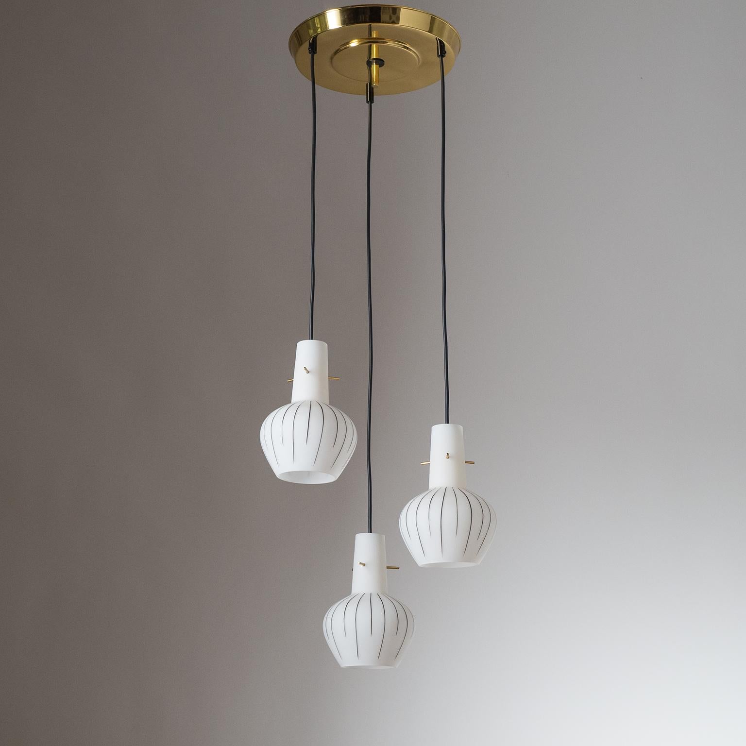 Italian cascading suspension chandelier from the 1960s. Suspended from a polished brass ceiling plate are three blown satin glass diffusers with hand-painted stripes. Original E14 sockets with new wiring.