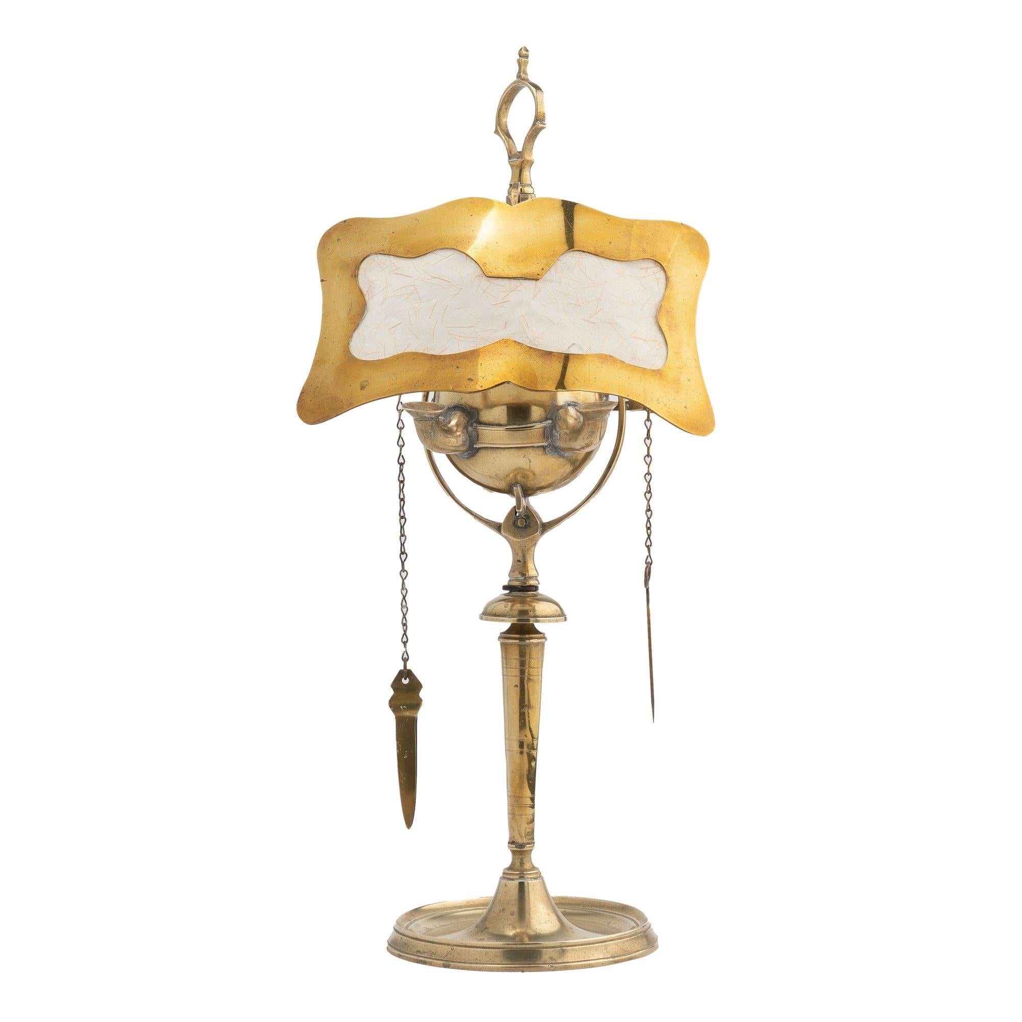 Cast brass two burner Lucerne oil lamp with hanging wick implements and fitted with its original brass deflector shade with rice paper insert.
Italian, circa 1800.