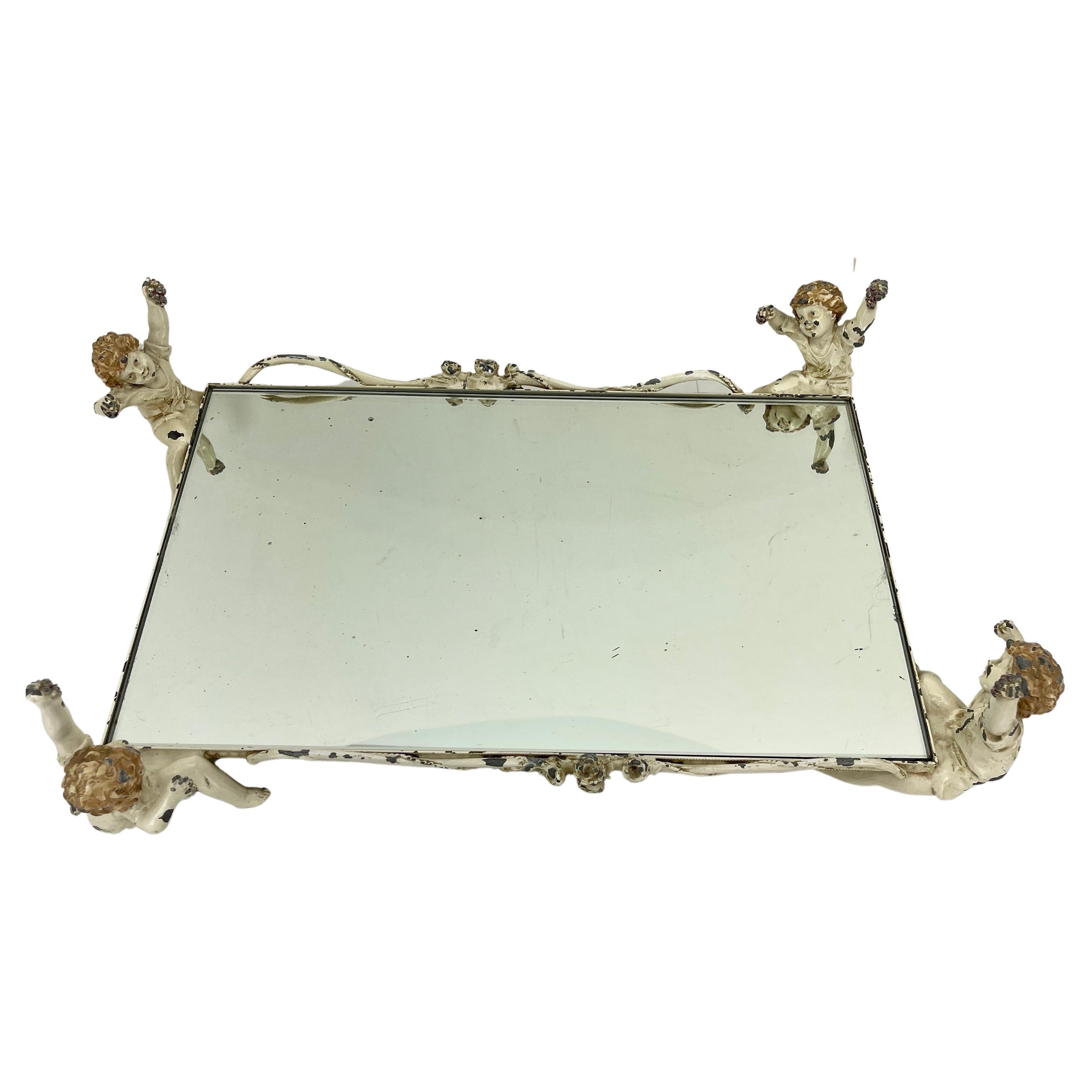 1920s Cast Iron Mirrored Cherub Tray and Centerpiece, Italy 

Charming tray from Italy featuring 4 lively iron cherubs on each corner. The attention to detail is apparent with each cherub holding wine grapes. The mirrored glass is removable and