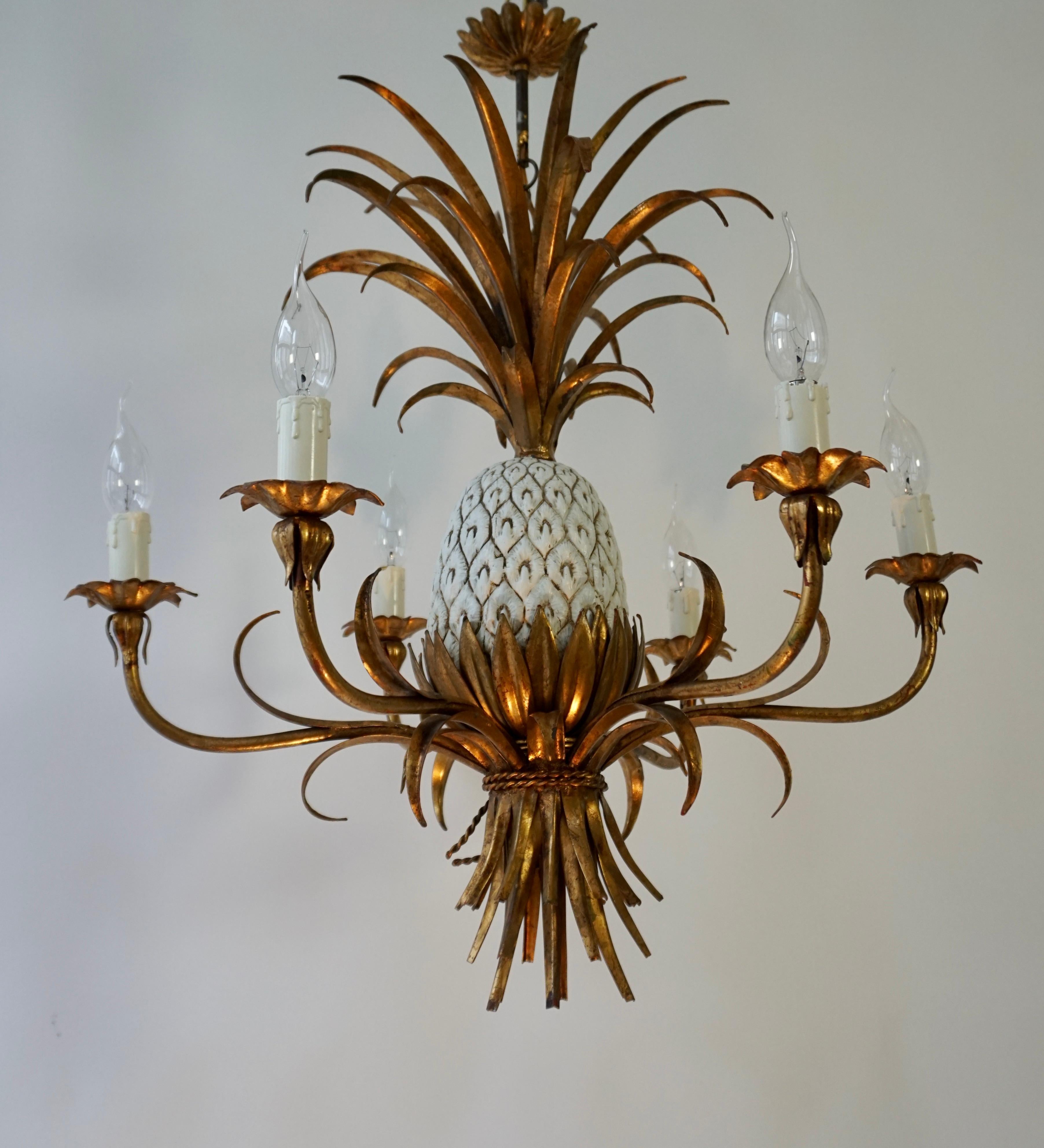 Beautiful ceramic pineapple chandelier with gilt acanthus leaf details and gilt fronds.

There are 6 arms each carrying a single lamp holder (e14) The chain leads to the original git ceiling rose.

Measures:70cm total height, 64 cm width, height