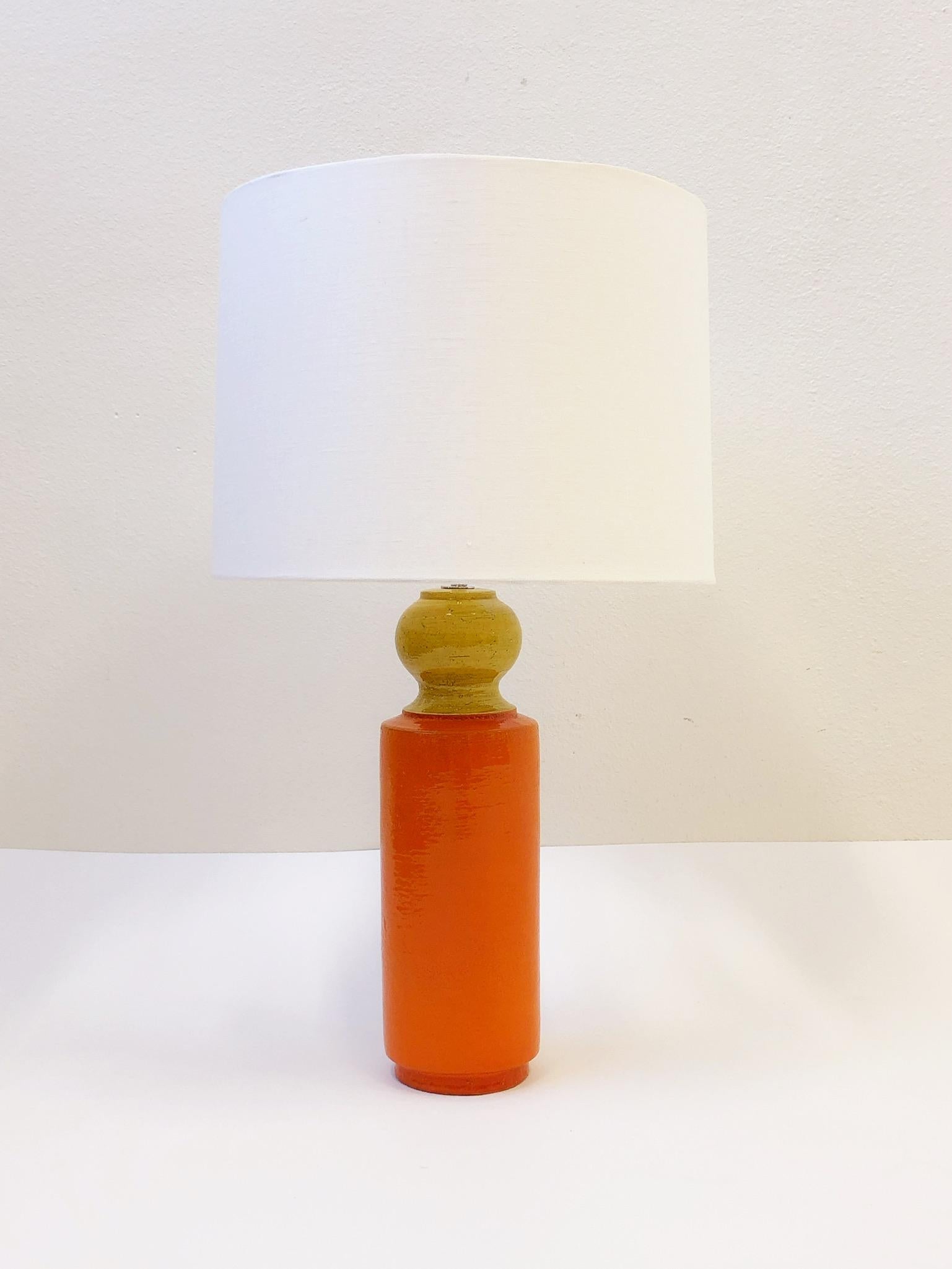 A beautiful 1970s Italian ceramic table lamp by Bitossi. The lamp is orange and mustard yellow glazed, newly rewired with new polish nickel hardware and new vanilla linen shade. 

Dimension: 31” high, 18” diameter.