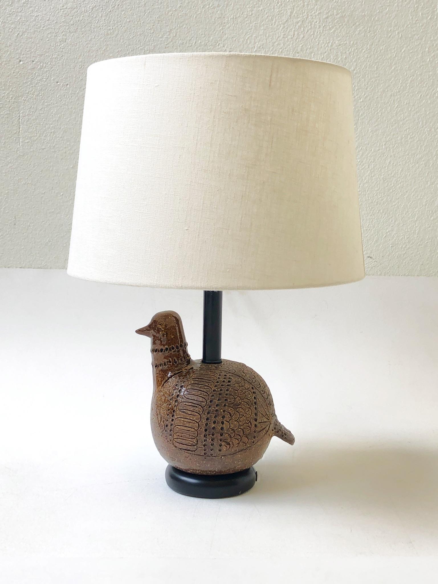 A charming Italian brown ceramic bird table lamp by Bitossi. The lamp was designed in the 1960s. The ceramic bird shows where the head was joined to the body (it’s not a cracked). Constructed of brown glazed ceramic with black lacquered and brass