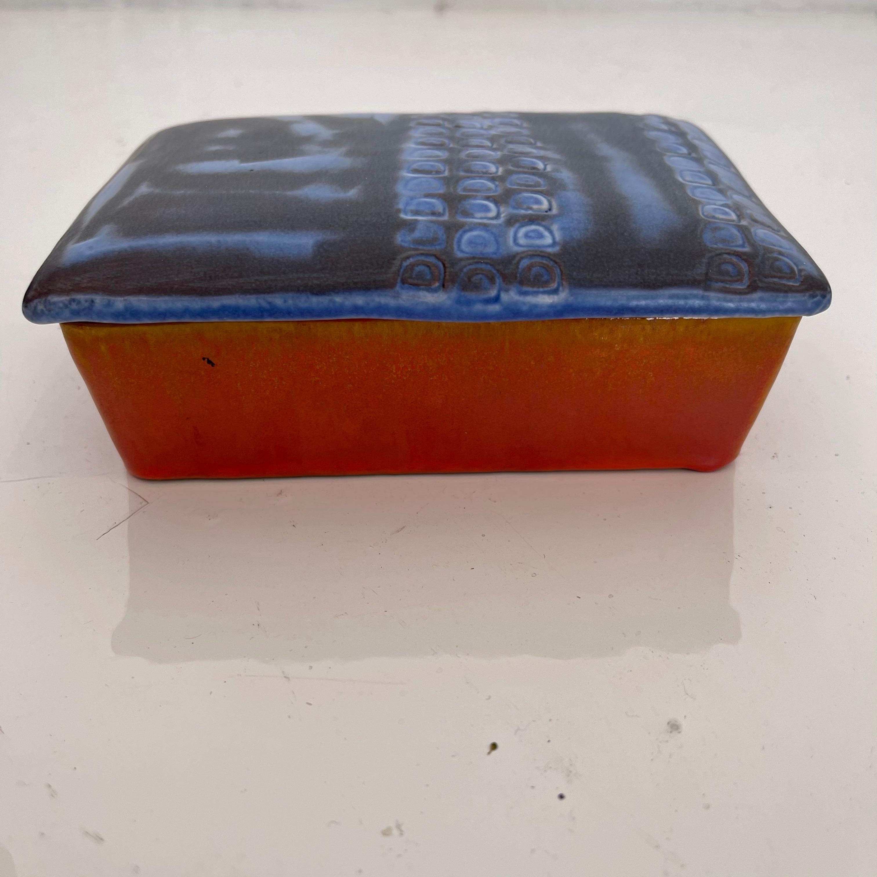 Fantastic ceramic box by Raymor. Stamped Raymor and Italy on underside. Orange base with blue and black lid. Cool colors and great design. Perfect box.