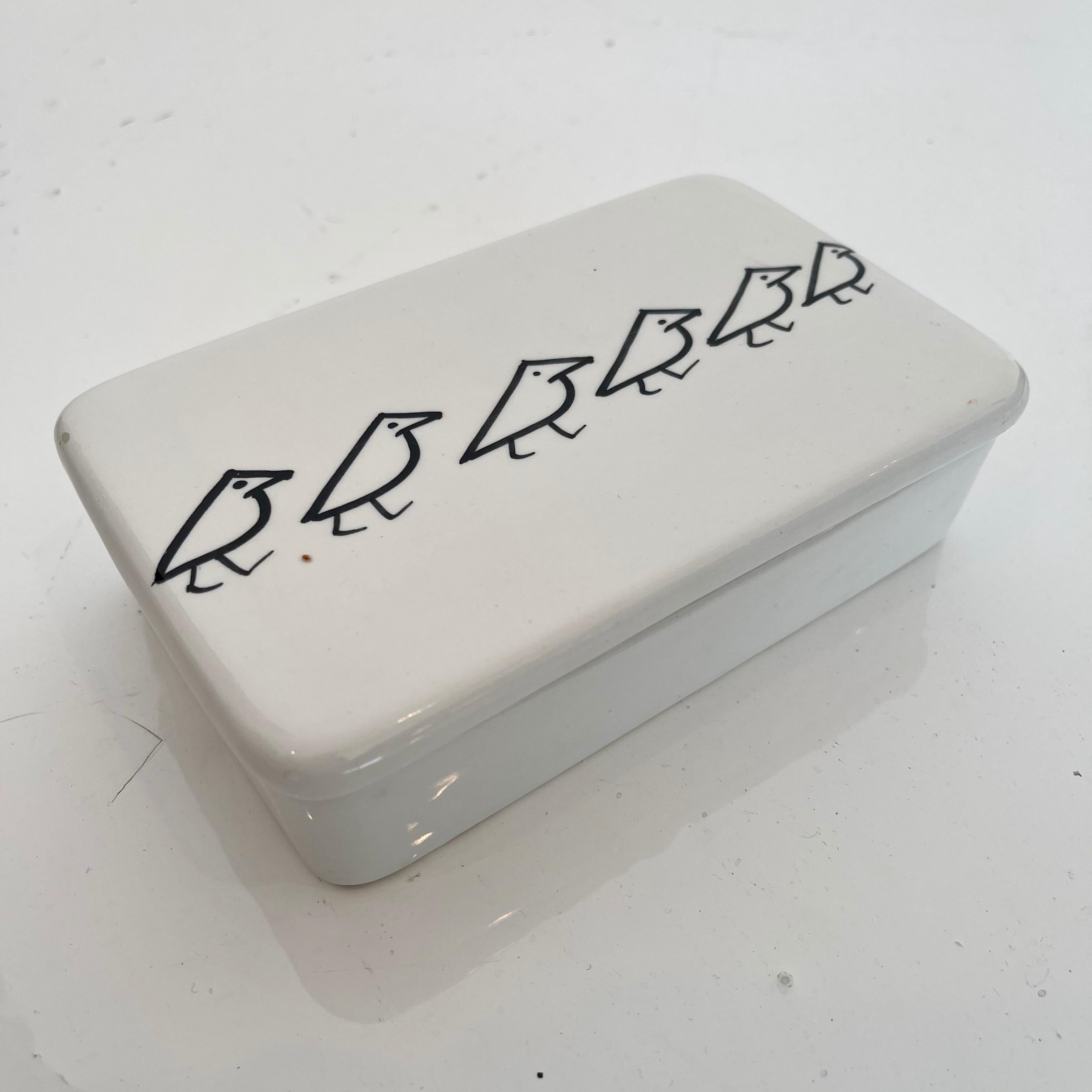 Caja de cerámica artística fabricada en Italia, hacia la década de 1970. Caja blanca con pájaros negros pintados. Gran estado vintage. Divertida caja escondite y objeto de mesa. Marcado Raymor y Made in Italy en la parte inferior.