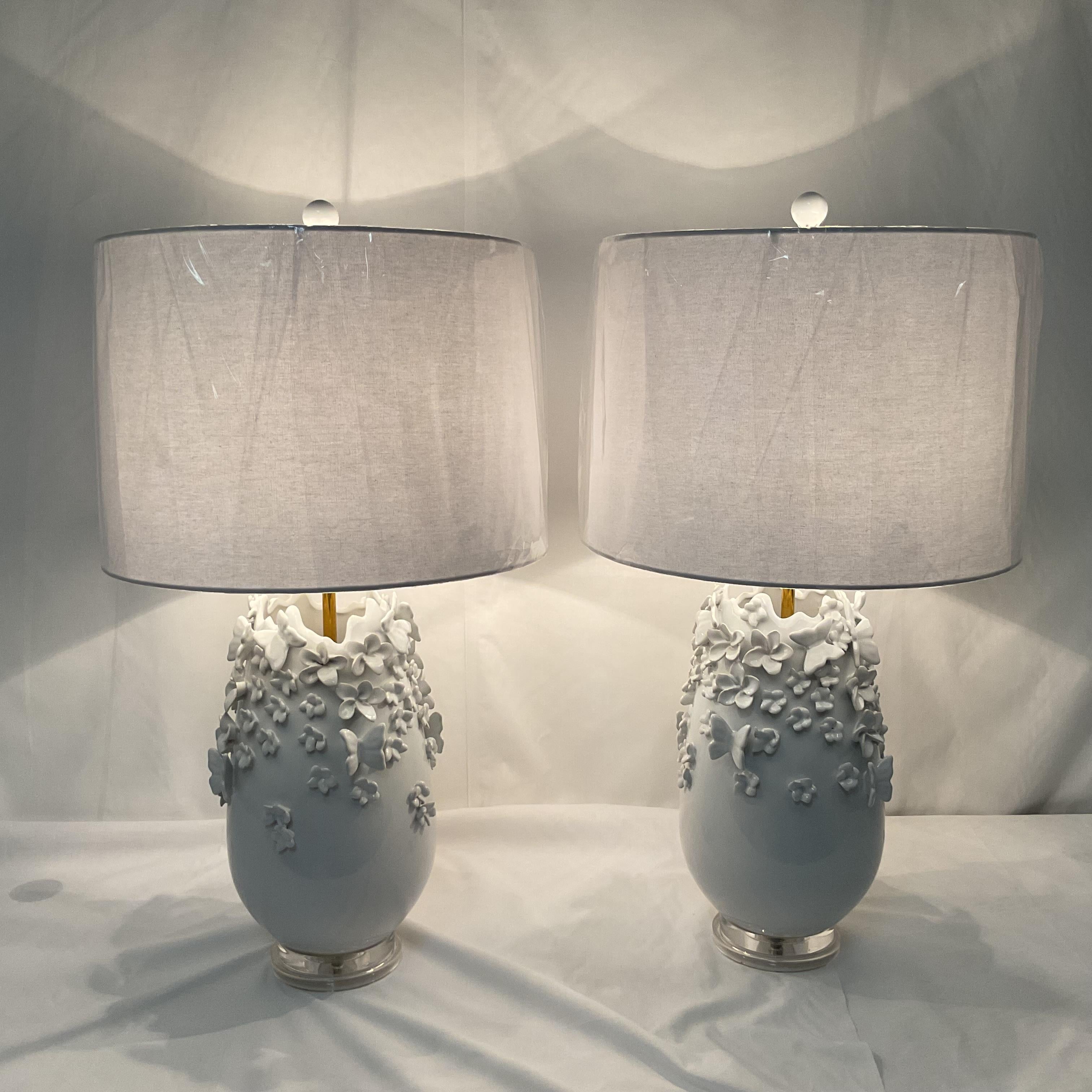 Aggiungi eleganza e charme alla tua casa con questa splendida coppia di lampade da tavolo in ceramica bianca. Ogni lampada presenta una base splendidamente scolpita e ornata da delicati accenti floreali in 3D, che danno un tocco di consistenza e