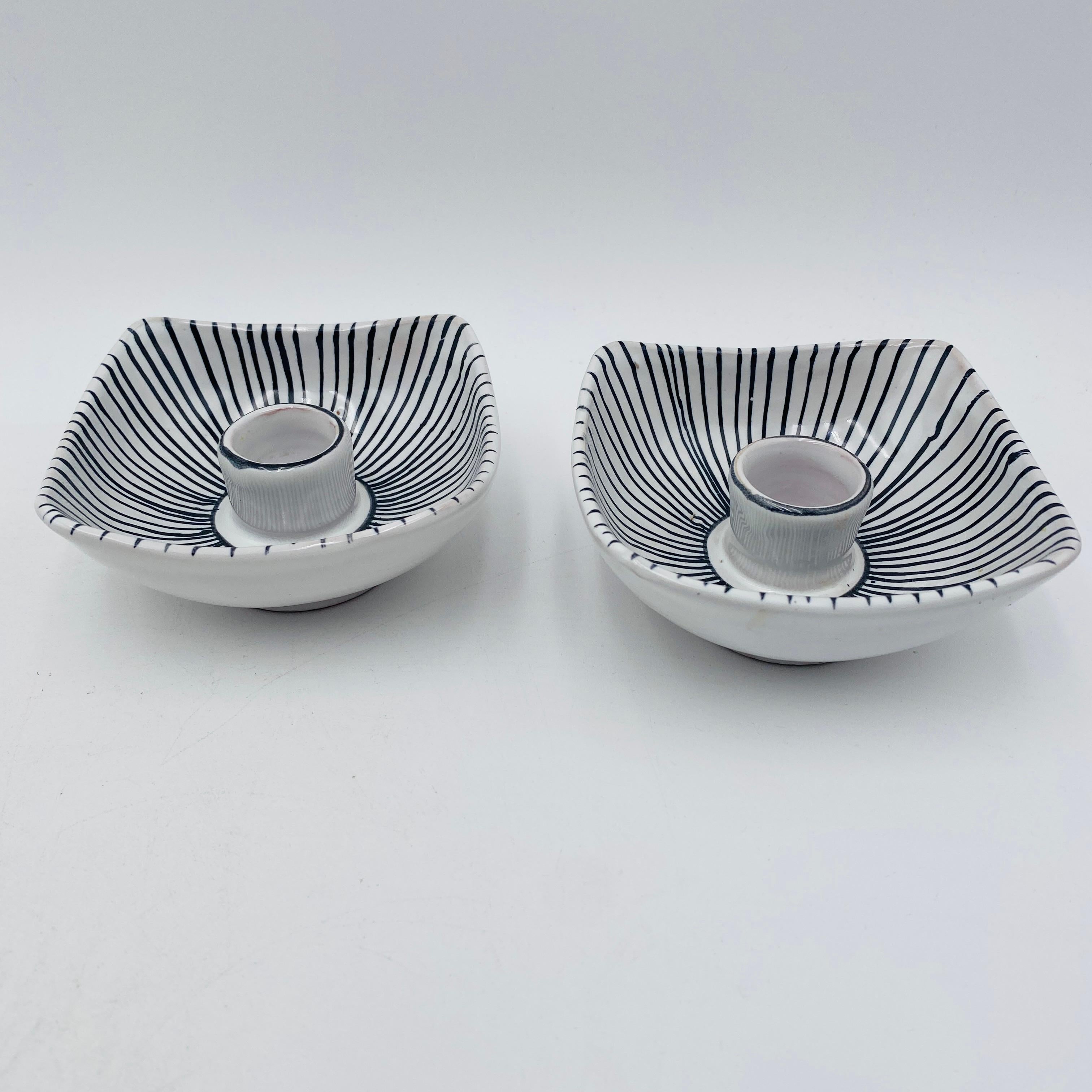 A beautiful pair of Italian ceramic hand-painted candlesticks. The bottoms are both signed 4140 Italy FB. They remind me of the style of Fornasetti with the black and white colors and modernist design. 