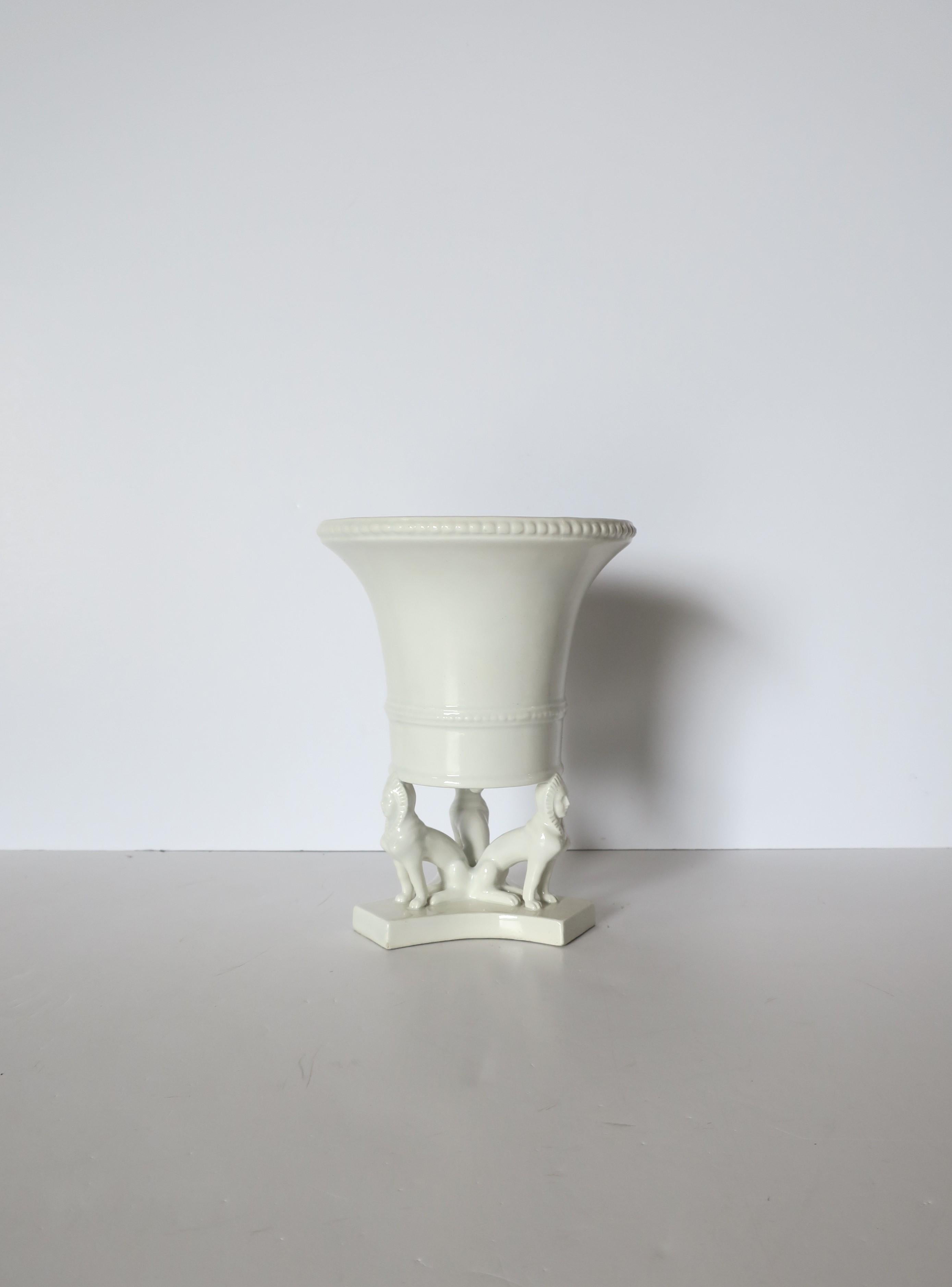Vase urne ou cache-pot en céramique blanche italienne de style néo-égyptien, vers la fin du XXe siècle, Italie. Vase ou cache-pot (bac à fleurs ou à plantes) de couleur blanche avec trois chiens pharaons égyptiens autour de la base. Magnifique en