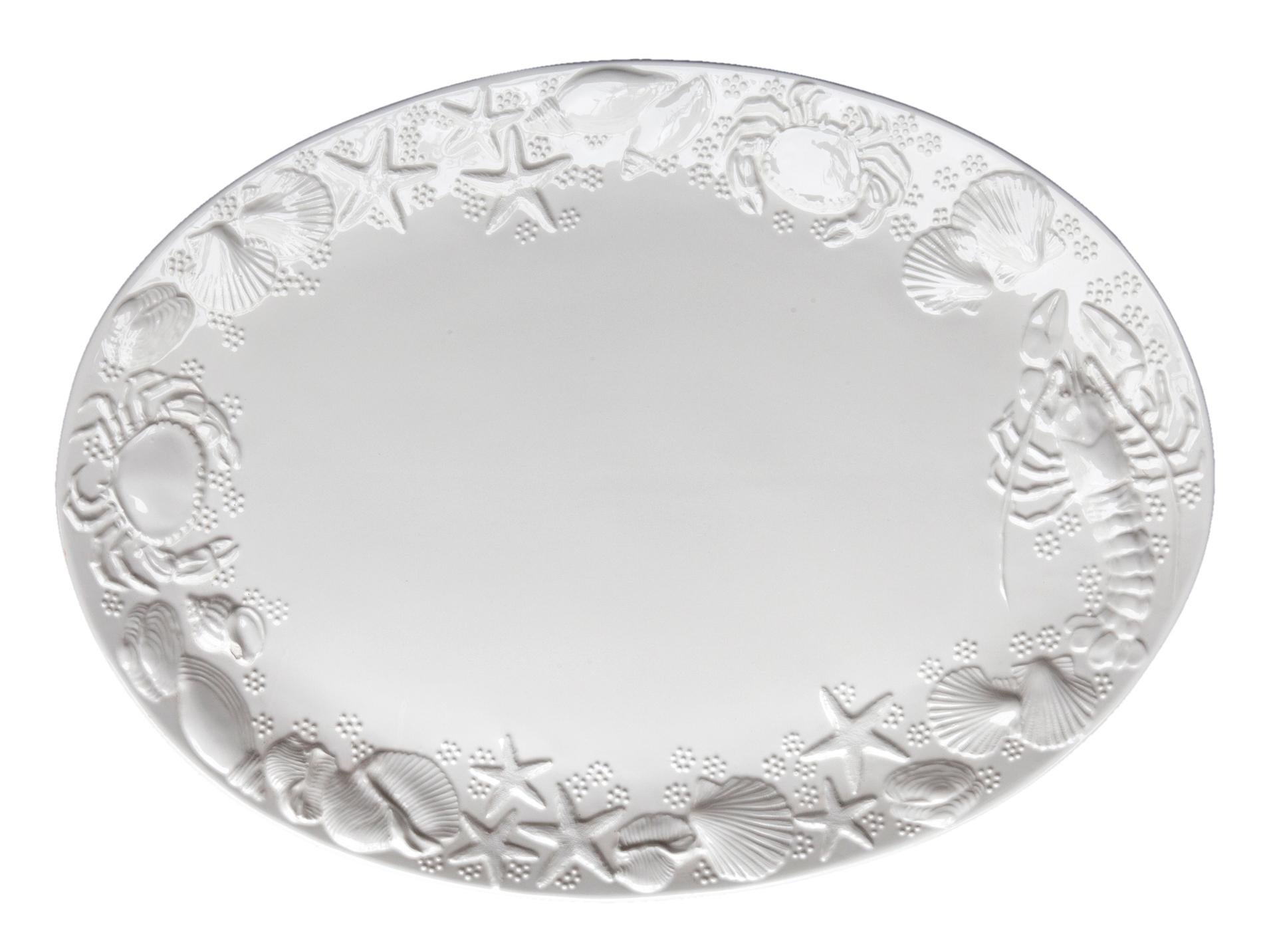 Large Italian ceramic serving platter featuring an embossed sea life motif.
Glossy white finish. Small spot missing the glaze, barely visible.