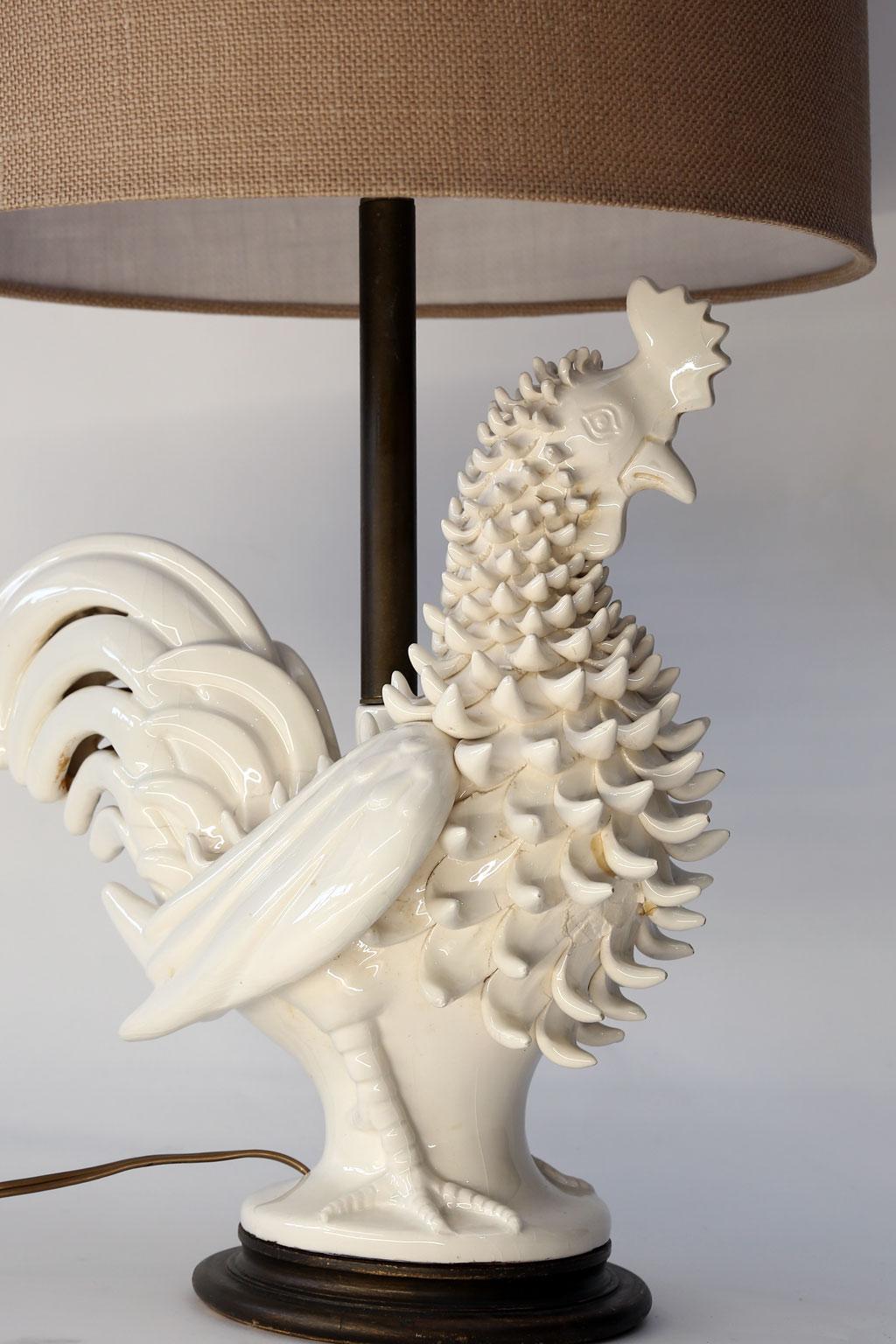 Italian ceramic rooster lamp, table lamp created from circa 1970s cream-color ceramic rooster, mounted on hand-painted turned wood base. Newly wired for use within the USA using all UL approved parts. Includes complementary rolled-edge burlap drum