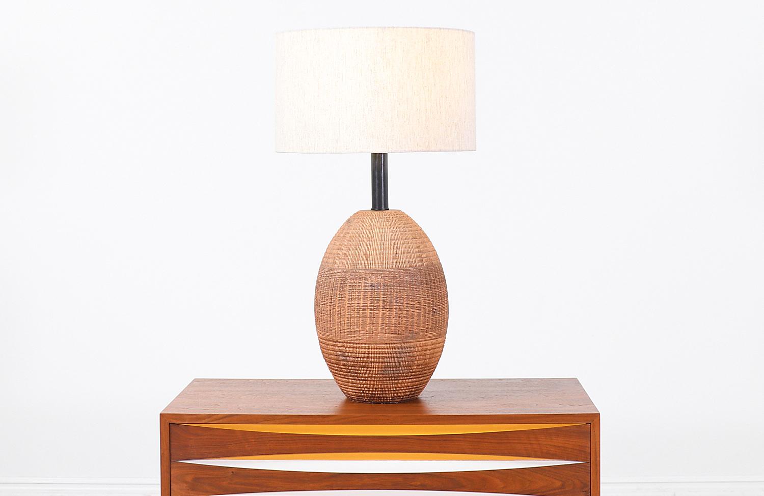 Stylish Italian modern table lamp designed and manufactured by Raymor in Italy circa 1960s. This beautifully textured lamp features a curved ceramic body with an intricate line pattern creating a wonderfully clean, asymmetric look to this textured