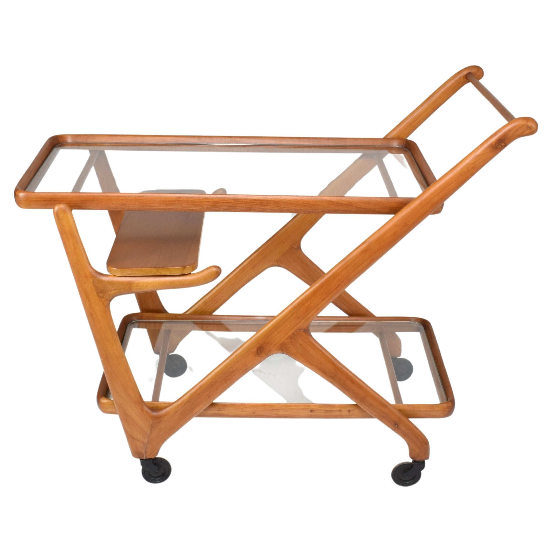 A striking 20th century Italian vintage serving bar cart with rollers designed by Cesare Lacca for Cassina in solid sculptural beechwood and glass. Designed with three removable trays and a comfortable handle, this stylish piece is the perfect