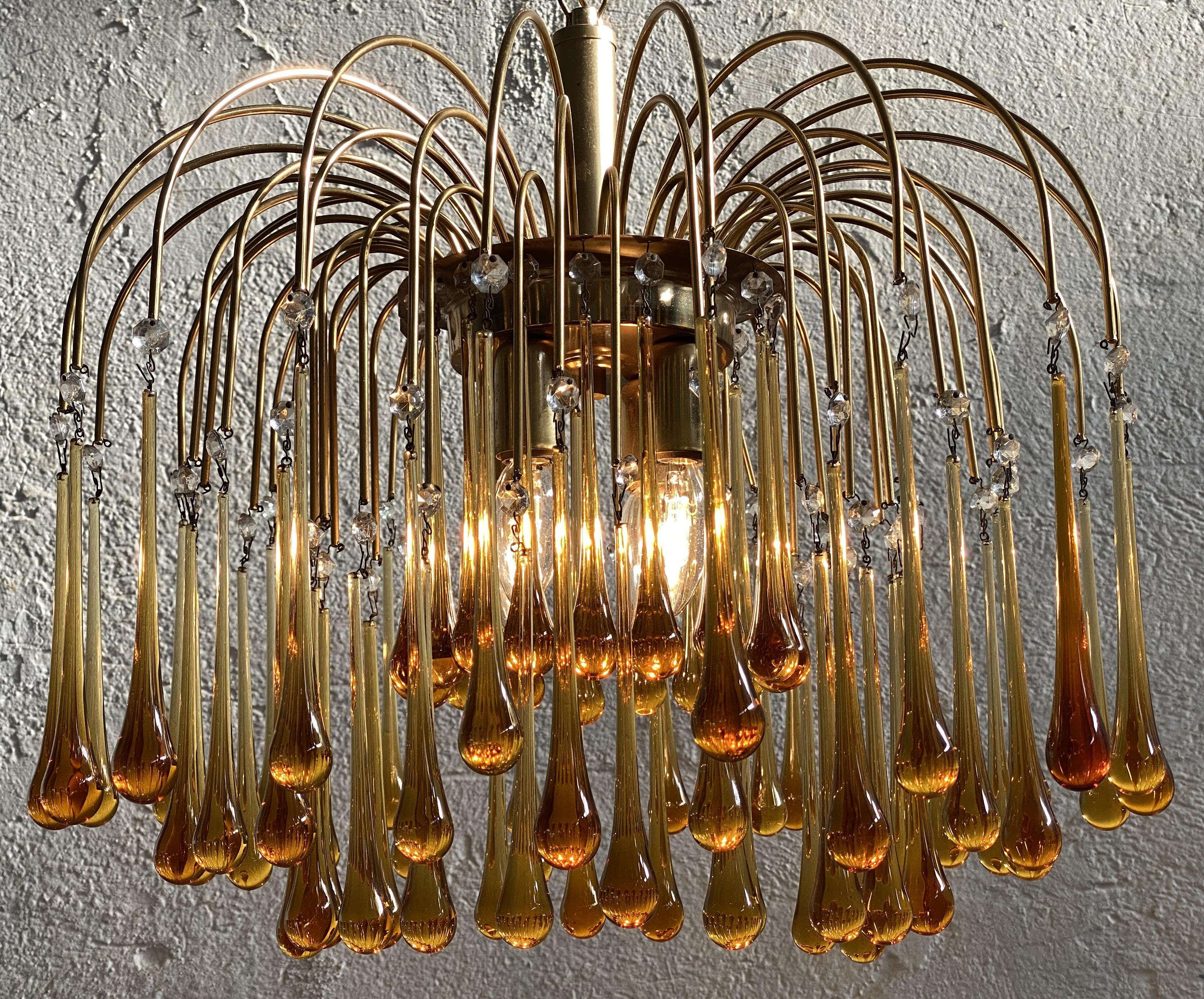 Elegant Venetian chandelier. Dozens of amber drops hang from the golden canopy. Four small lights..
   