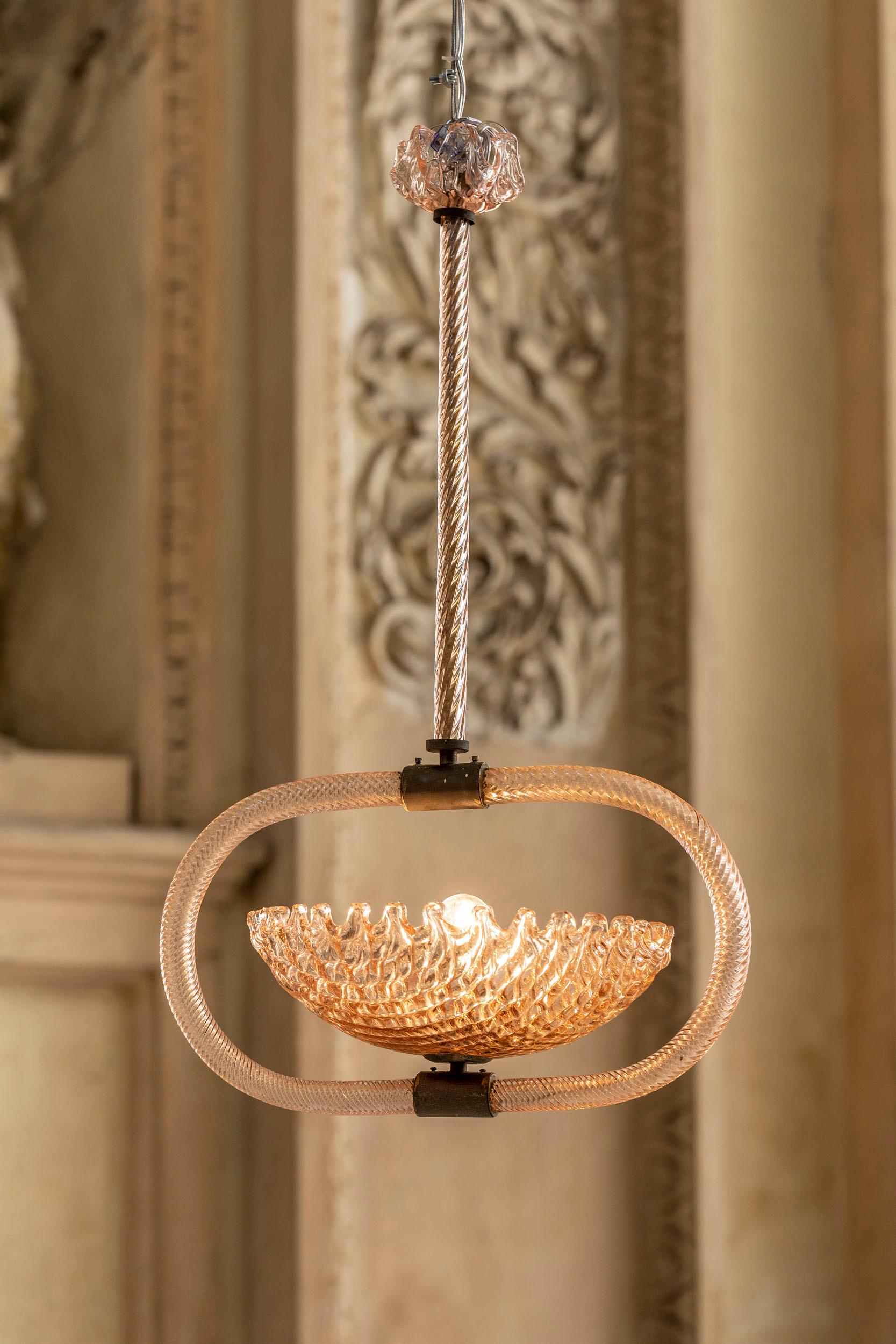 Italian Ercole Barovier chandelier in rare Murano handblown pink glass with brass details.
This item presents two textured cups and two torchon glass rods details, all in the tone of light pink.
Italy, 1940 circa.