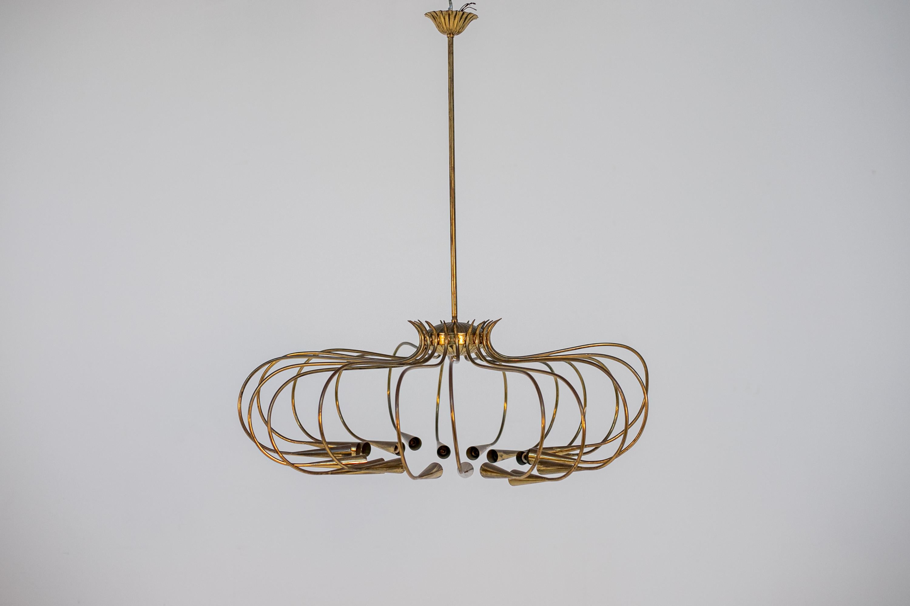 Large Italian chandelier from the 1950s by Oscar Torlasco for the Lumi manufactory. The chandelier is made entirely of brass. The chandelier is composed of seventeen arms made of brass stem. At the end of each brass stem there is a brass bulb