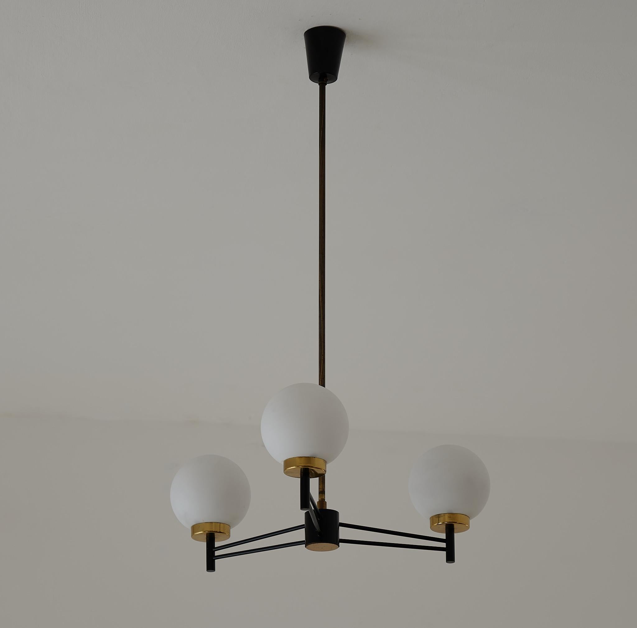 Italian pendant chandelier with three arms, made with black enameled iron, brass and 3 opaline glass globes .


Elegant and modern design , typical of Italian lamps of the 1950s

3 standard E14 bulbs.