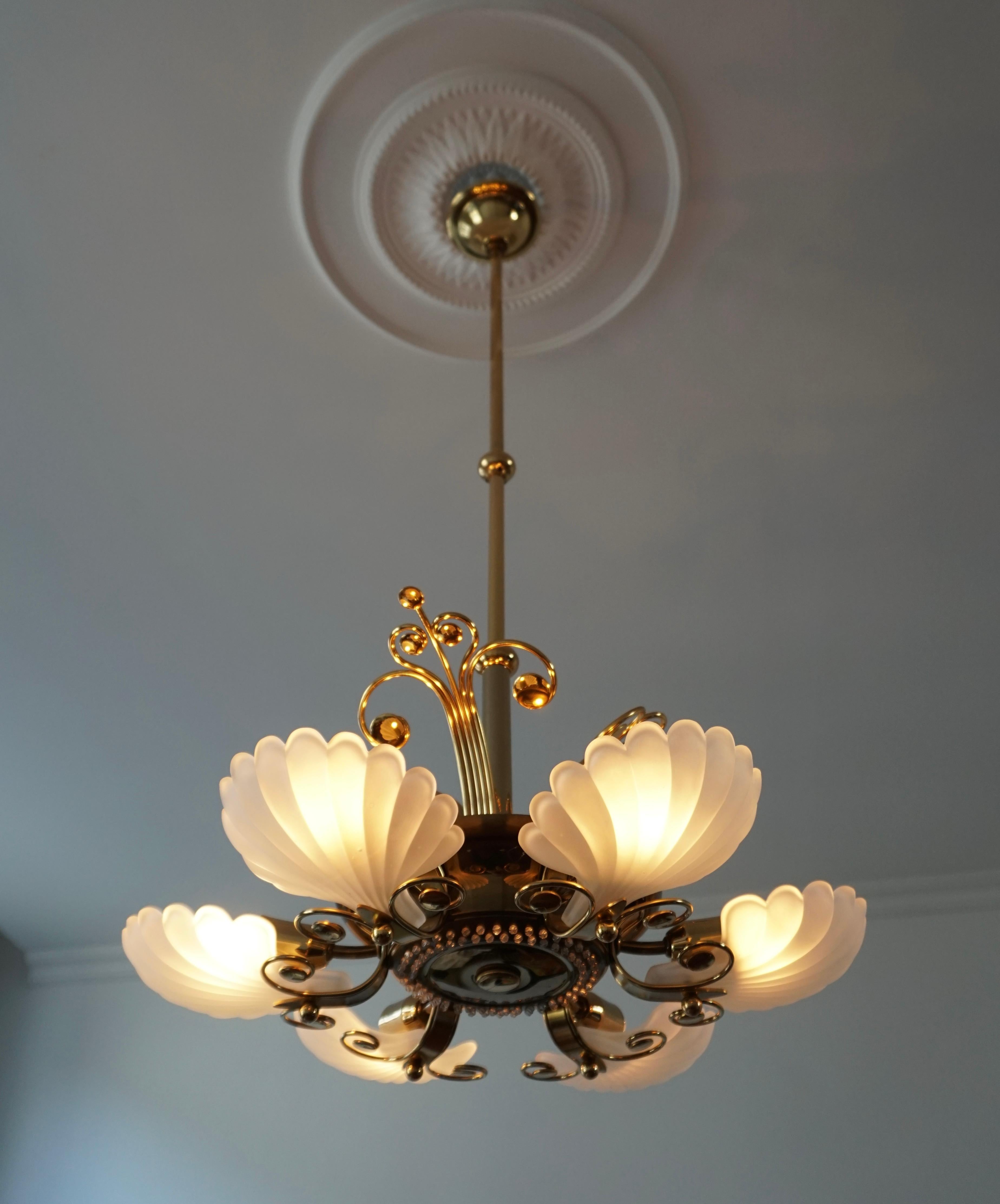 Wonderful chandelier made in Italy with six beautiful characteristic Murano frosted glass shells on a brass base. 

Measures: Diameter 55 cm.
Total height 115 cm.
The brass rod can be shortened to 60 and 32 cm.
The light requires nine single
