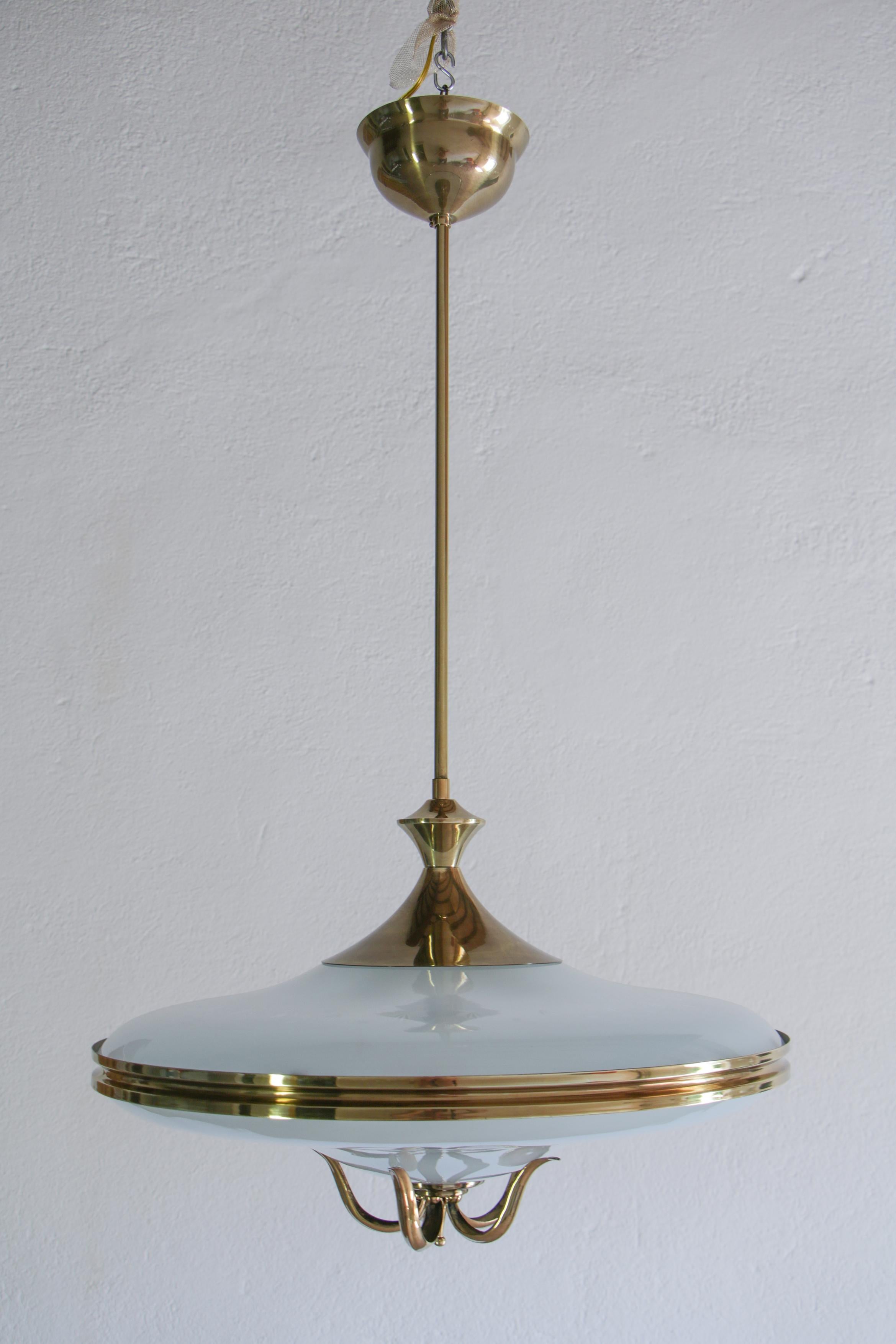 Superb Italian Mid-Century Modern chandelier attributed to Pietro Chiesa, produced in the 1950s. Structure made of polished brass, frosted, and ground glass. It characterized the glass disk elegance by prestigious brass decoration. A specialized