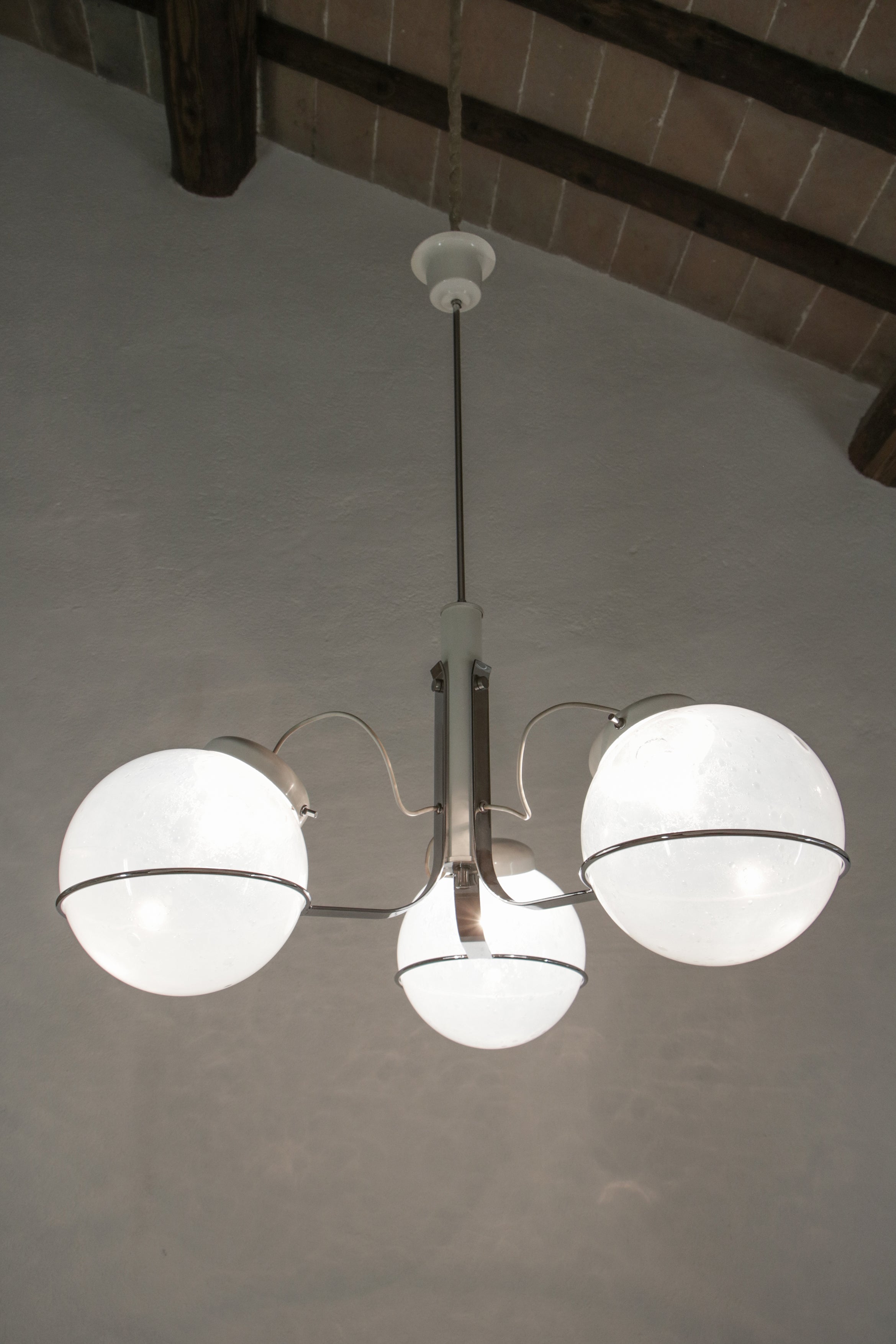 Splendido lampadario a sospensione italiano in vetro bullicante di Murano attribuito a Gino Sarfatti, degli anni '70. Struttura in metallo cromato e vetro di Murano. L'originale vetro bullicante a globo rende questo lampadario un pezzo unico. Un