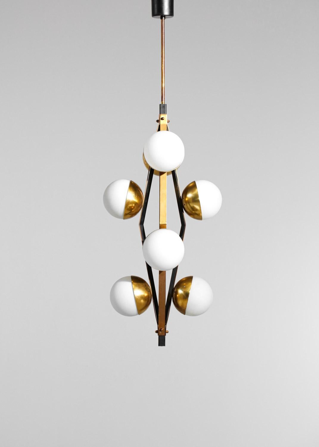 Italian chandelier of the 60's edited by the house Stilnovo. Structure of the light formed by 4 branches in black lacquered metal and solid brass on which rest 2 globes (of origin) in opaque white opaline. Very nice vintage condition with a